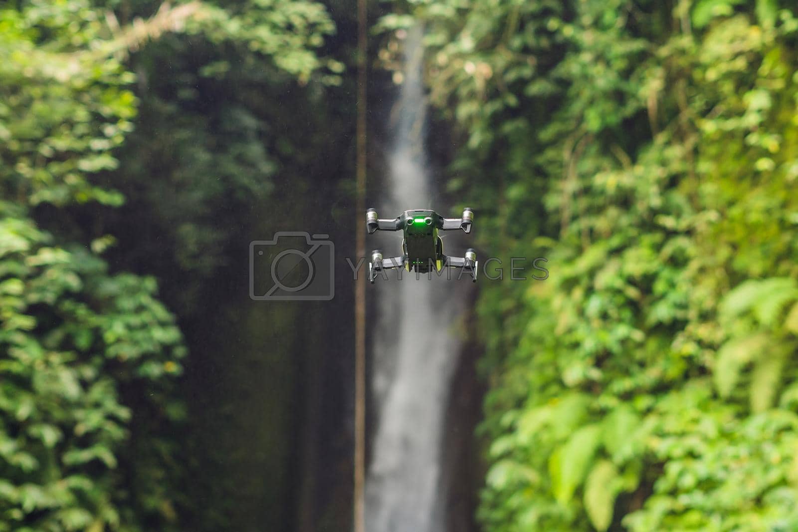 Royalty free image of Little quadcopter flying around waterfall Leke Leke Bali island Indonesia by galitskaya