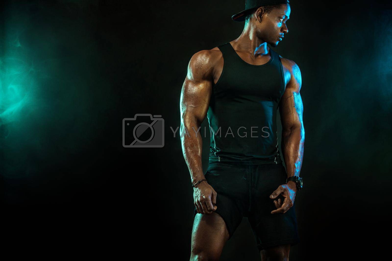 Royalty free image of Sports men athlete on dark background. Power athletic guy bodybuilder doing fitness training. by MikeOrlov