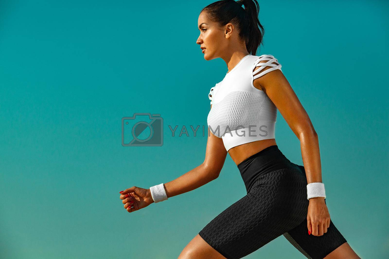 Sporty and fit young woman athlete training at the desert. Cloudy day on coast. The concept of a healthy lifestyle and sport. Woman in white sportswear.
