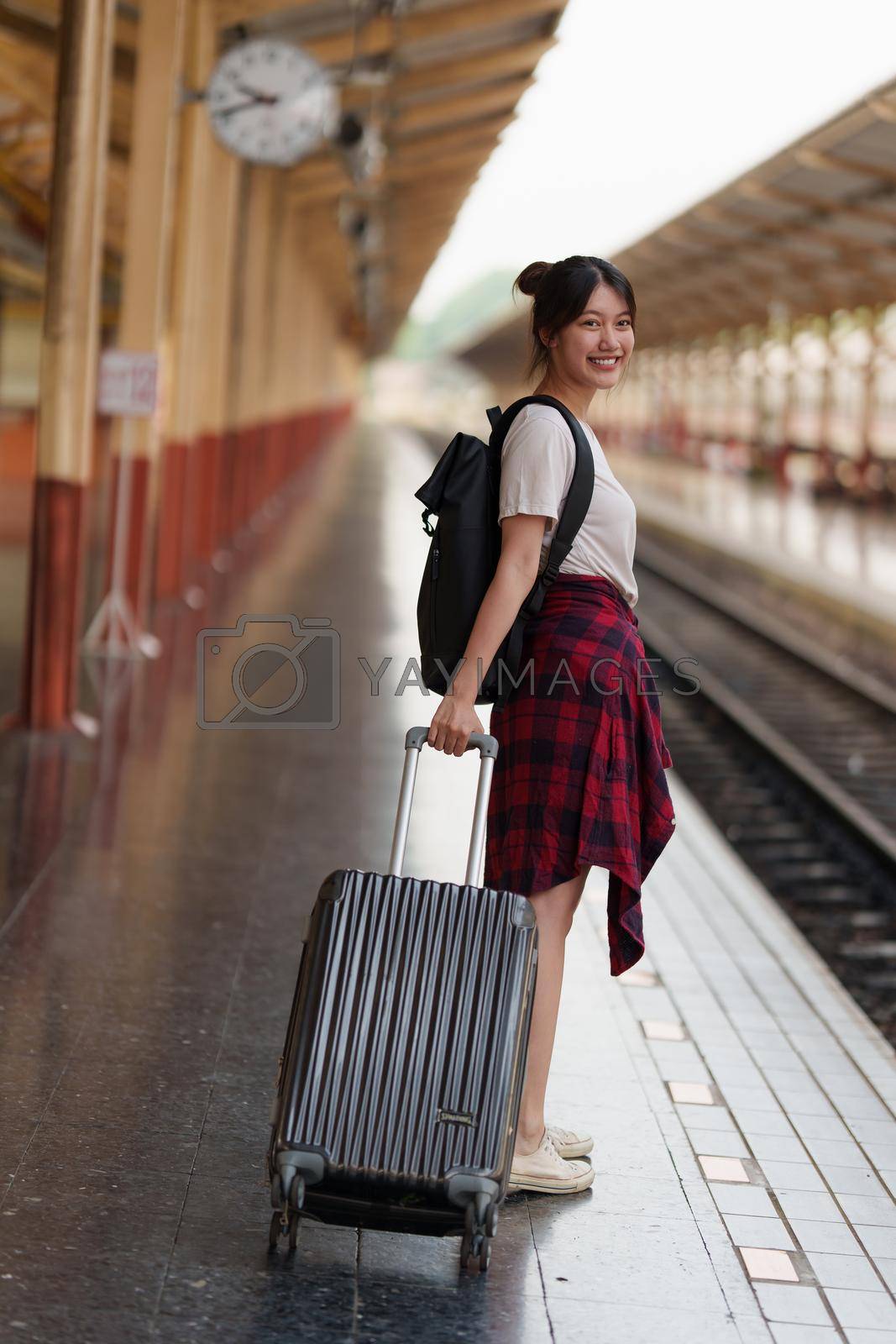 Royalty free image of Young traveler woman planning trip at train station. Summer and travel lifestyle concept. by itchaznong