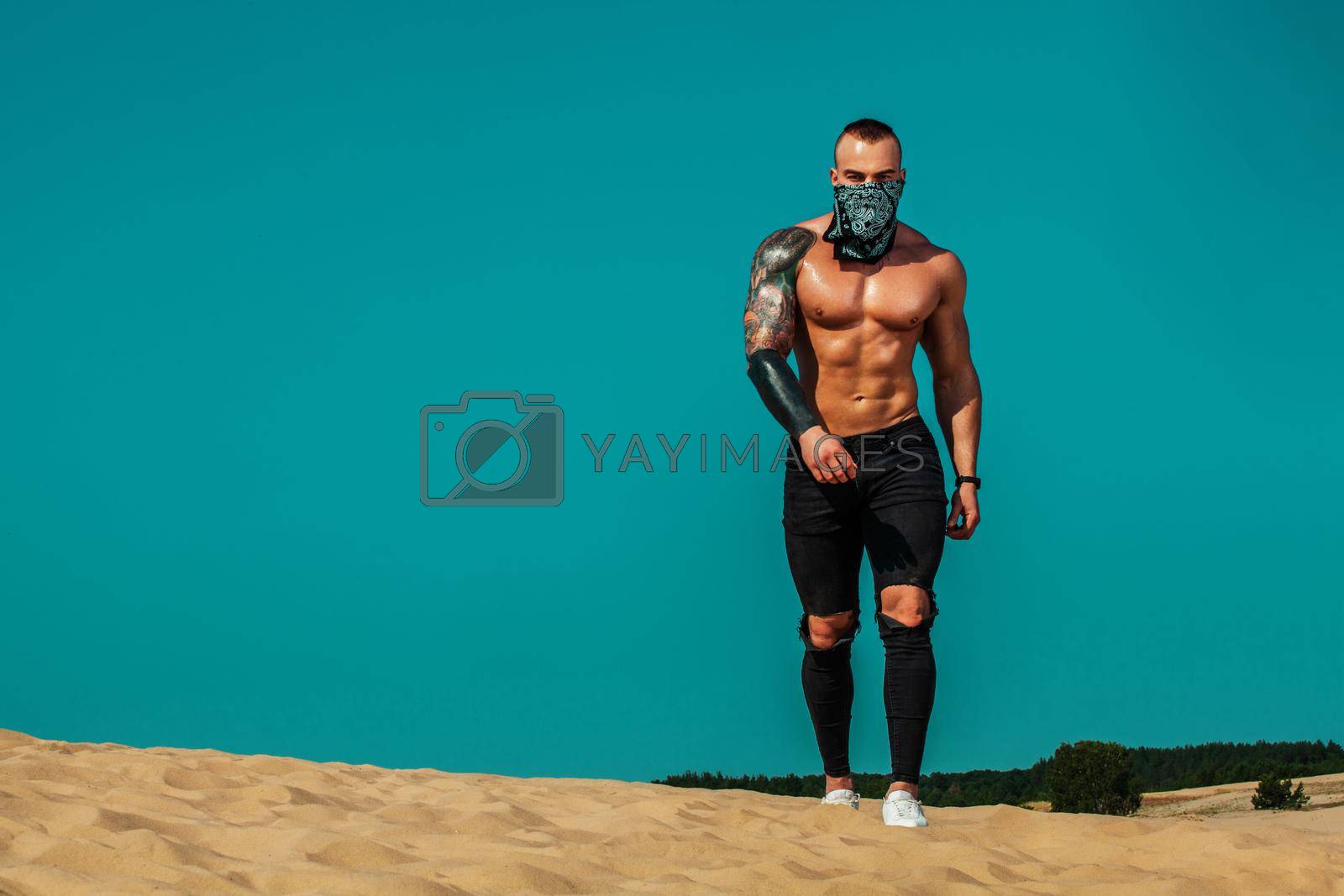 Royalty free image of Sportsmen men, fit athlete are standing on the sky background at desert. Healthy lifestyle and sport. Fitness concept. by MikeOrlov