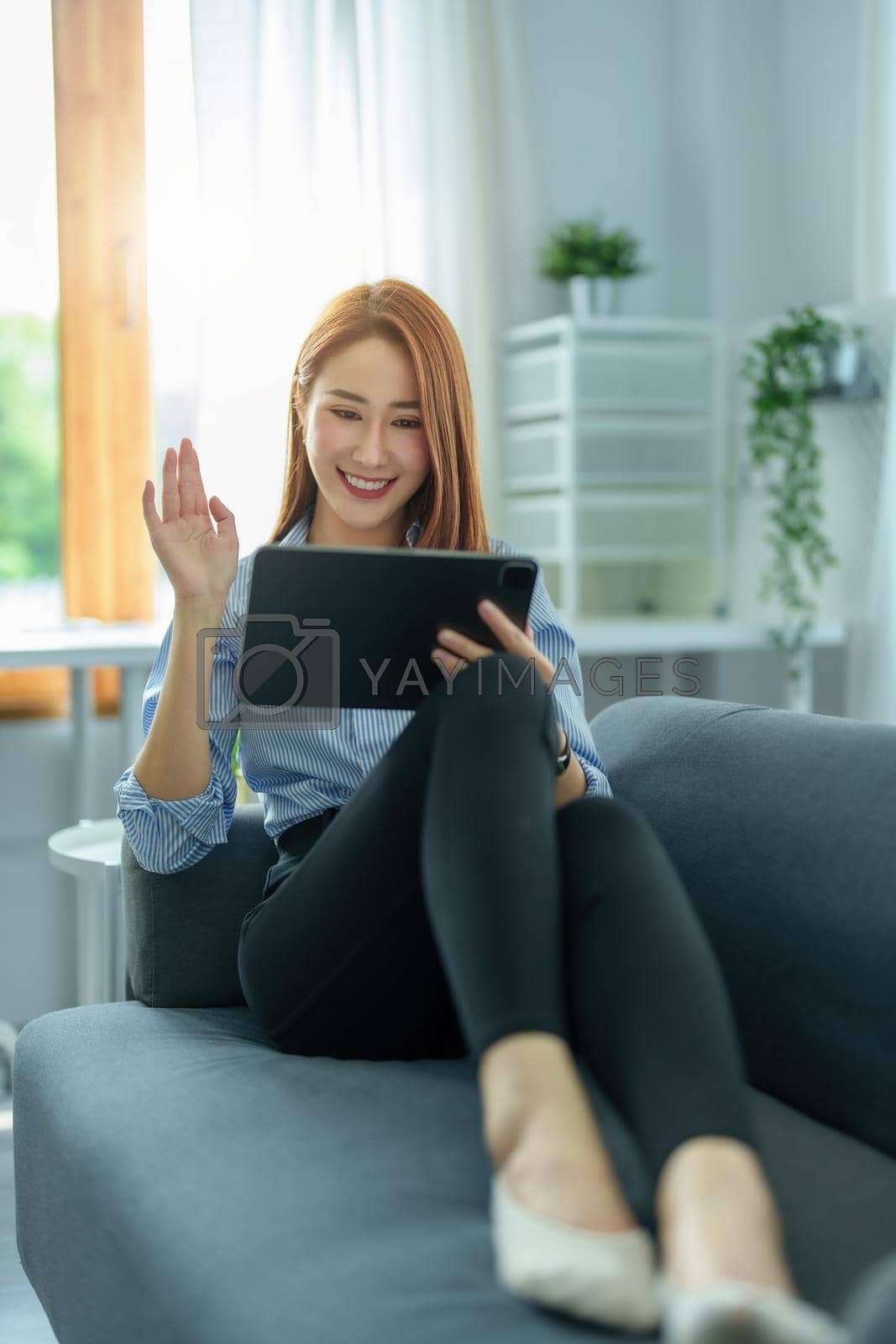Royalty free image of Conversation, online teaching, explaining, meeting, business owner, portrait of an Asian woman using a tablet for video conference with colleagues. work from home in the era of corona virus by Manastrong