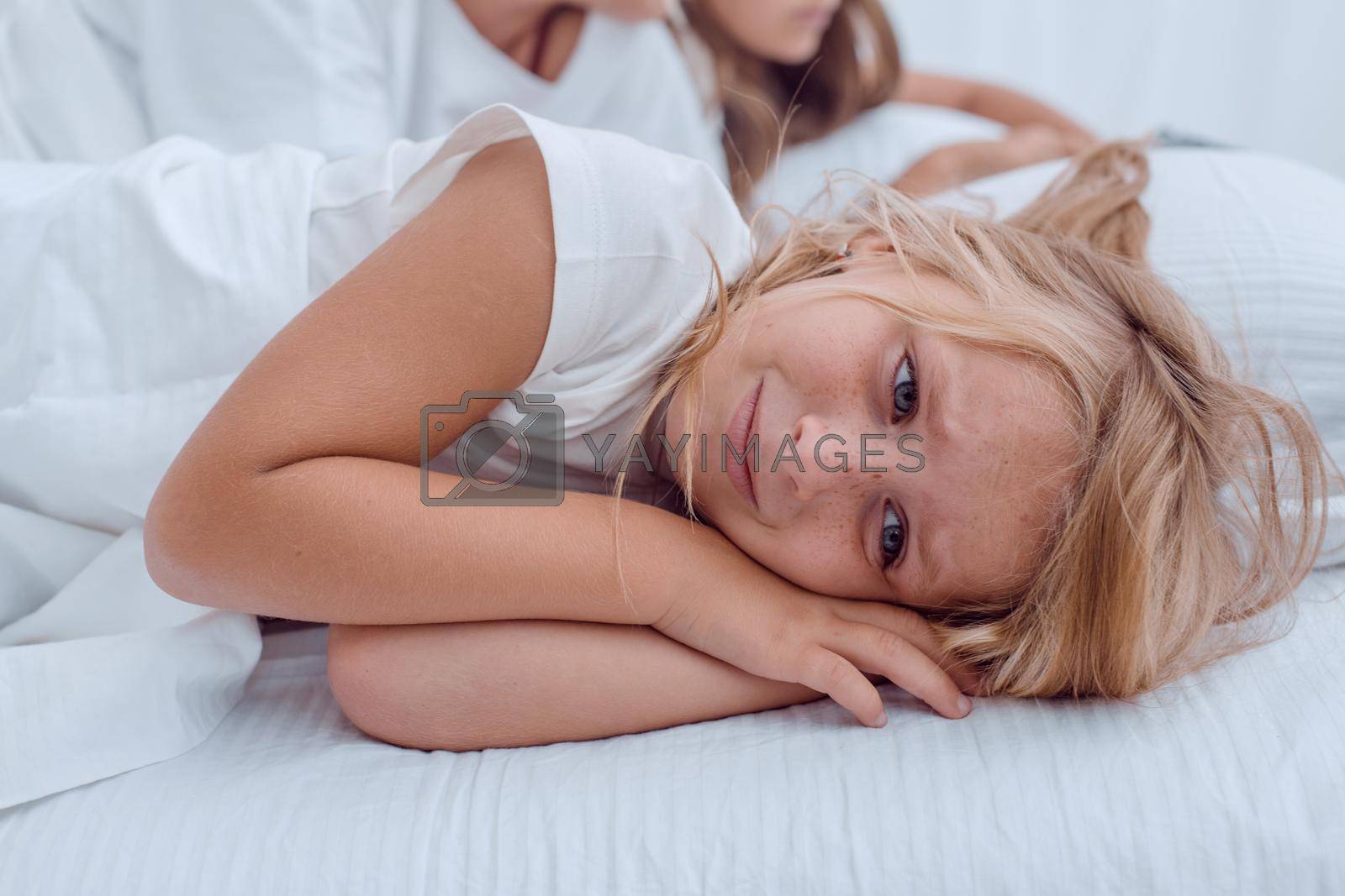 Royalty free image of pretty little girl lying on her parents bed by asdf