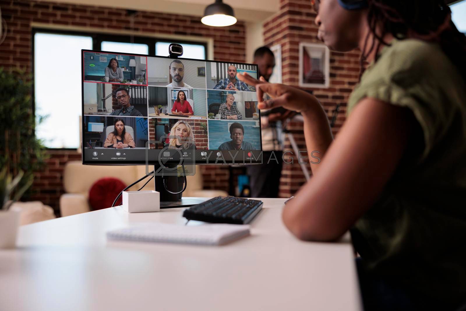 Royalty free image of Selective focus on computer screen with startup team of startup employees working remote in group video call by DCStudio