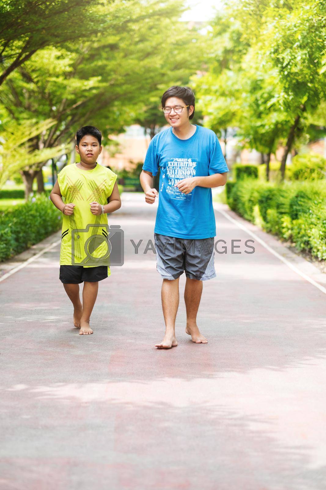 Royalty free image of Asian couple of brother run together in park. by Benzoix