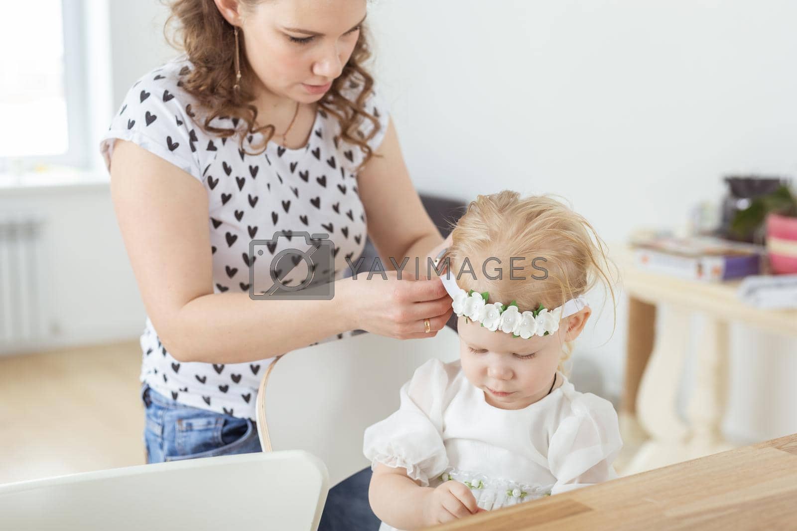 Royalty free image of Mother helps to put on cochlear implant for her deaf little daughter. Hearing aid and deafness concept by Satura86