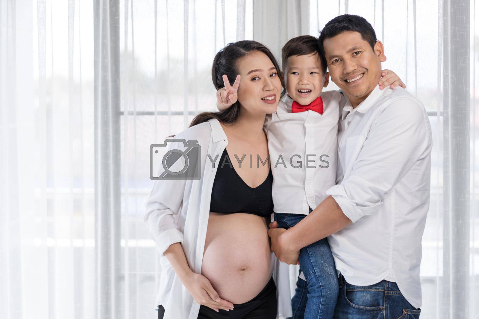 happy family concept, pregnant mother, father and son hugging