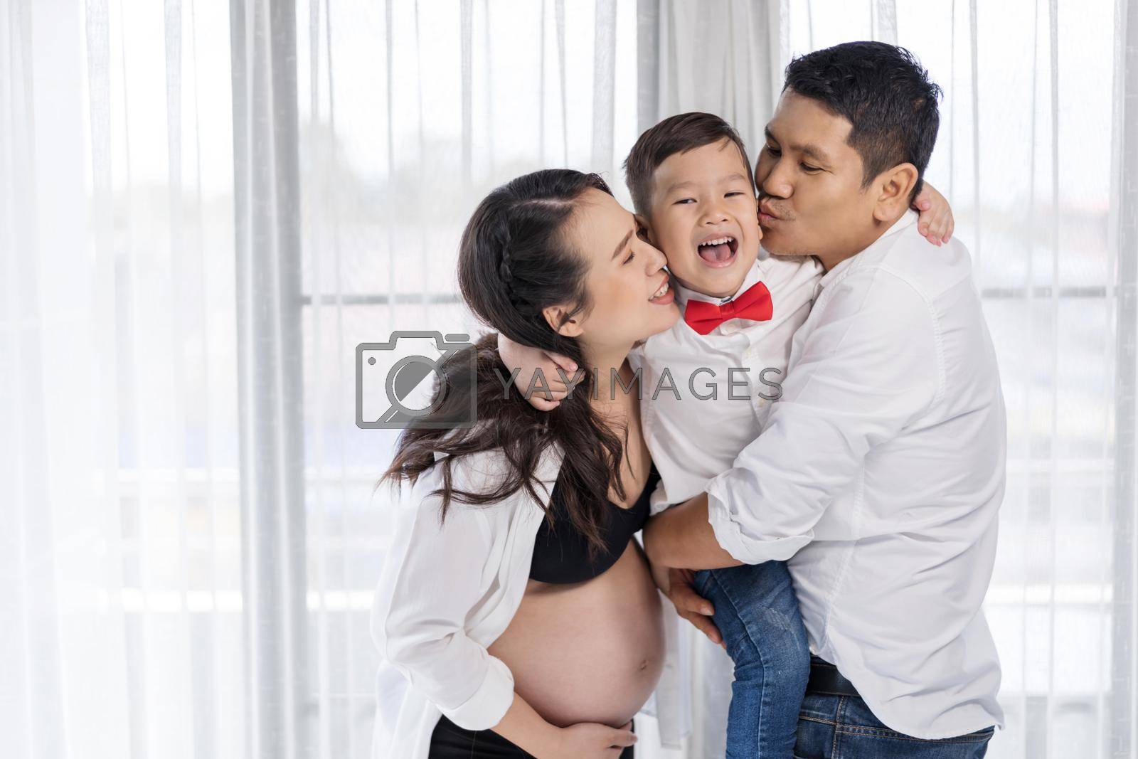 happy family concept, pregnant mother and father kissing kid boy 