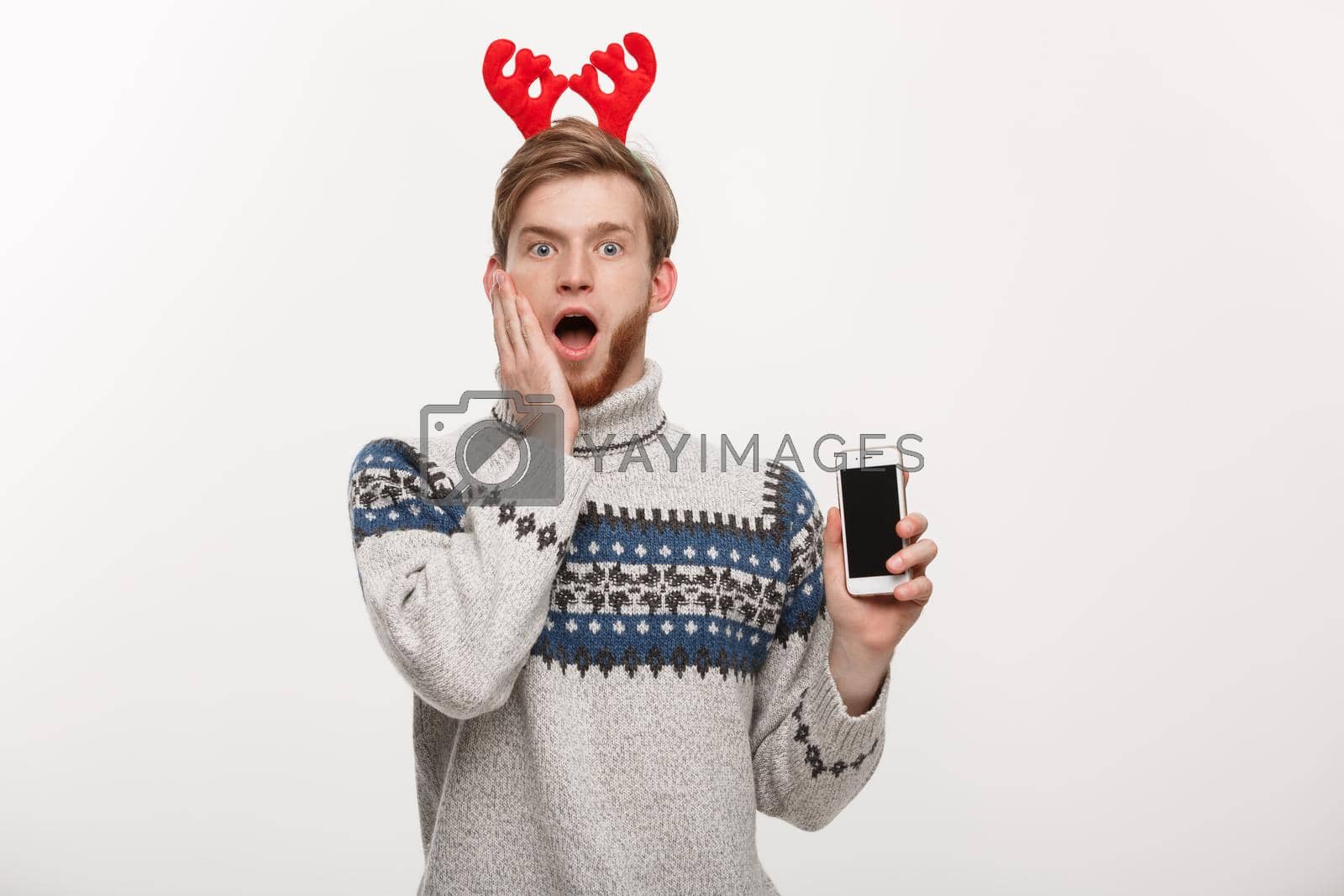 Royalty free image of Holiday and lifestyle concept - young beard handsome man surprising with something in mobile phone. by Benzoix