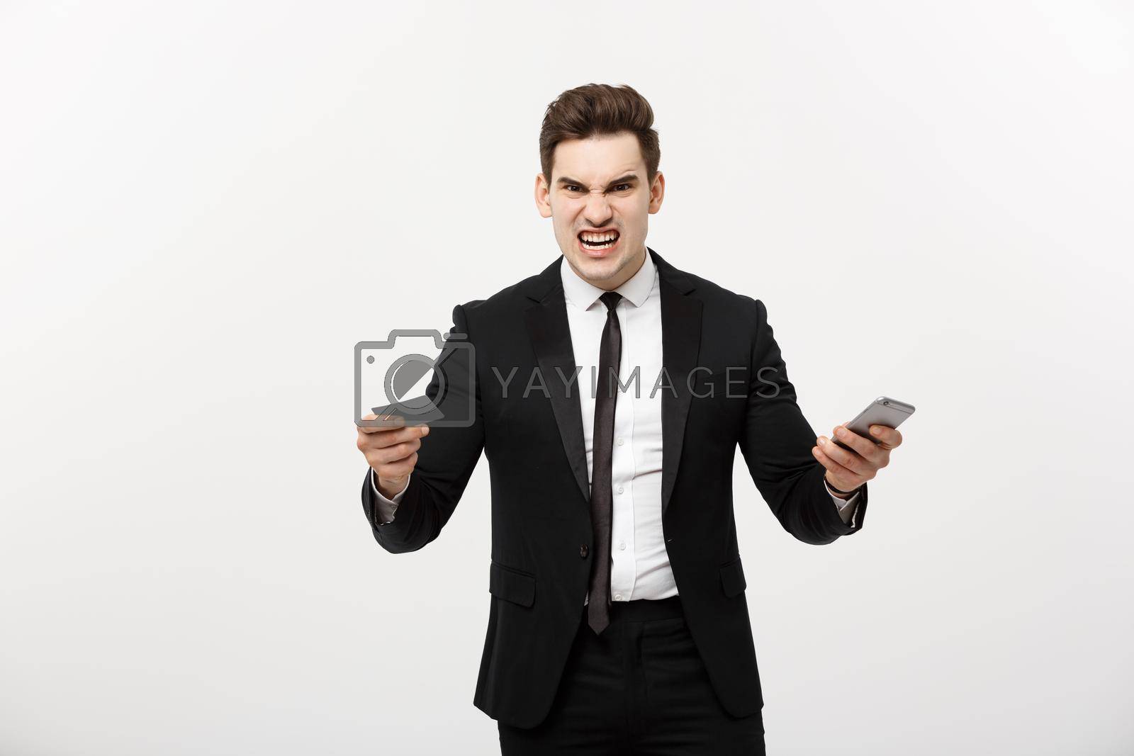 Royalty free image of Angry businessman holding credit card and mobile phone. Get Mad while shopping online or business problem. by Benzoix