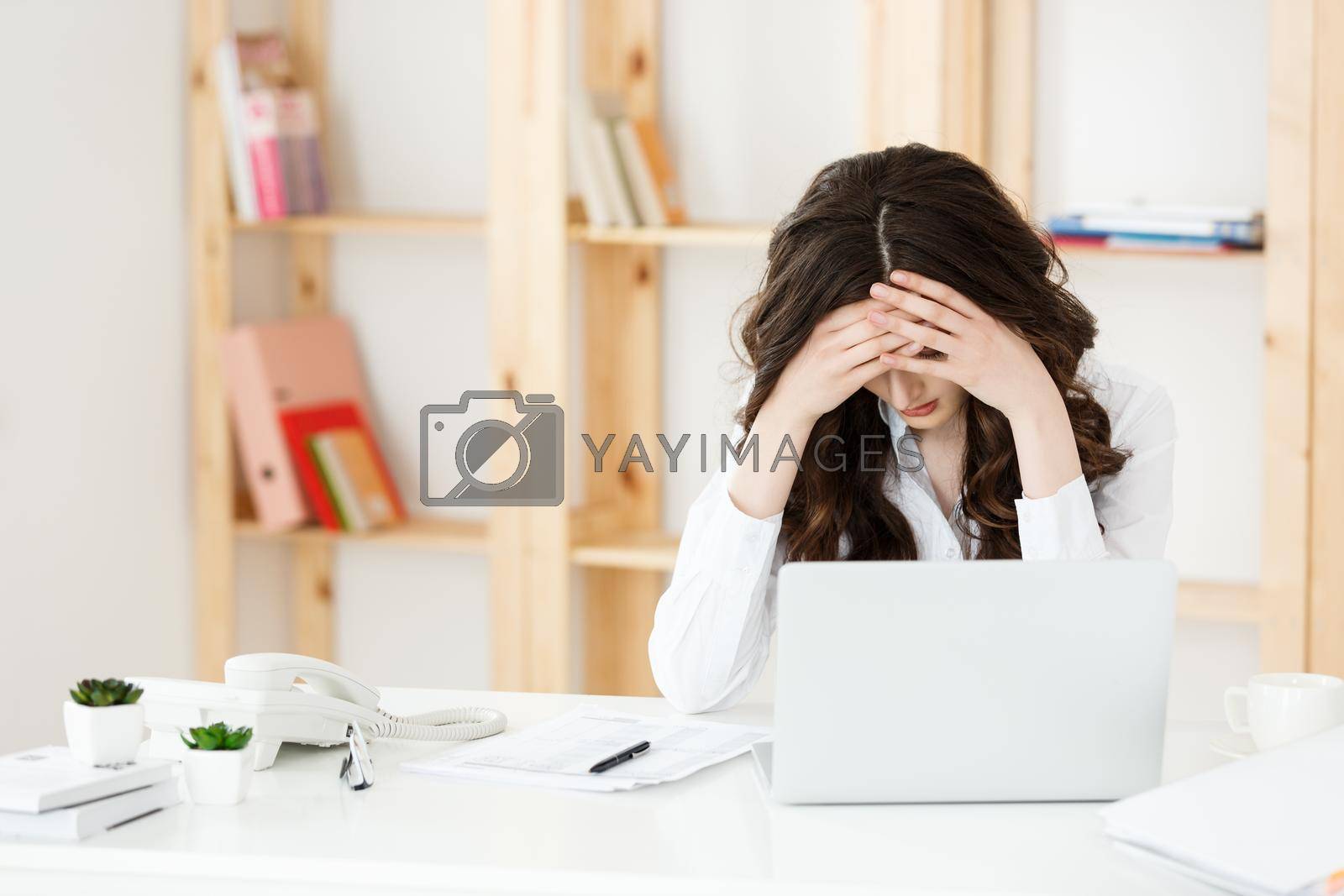Royalty free image of Tired young businesswoman suffering from long time sitting at computer desk in office by Benzoix
