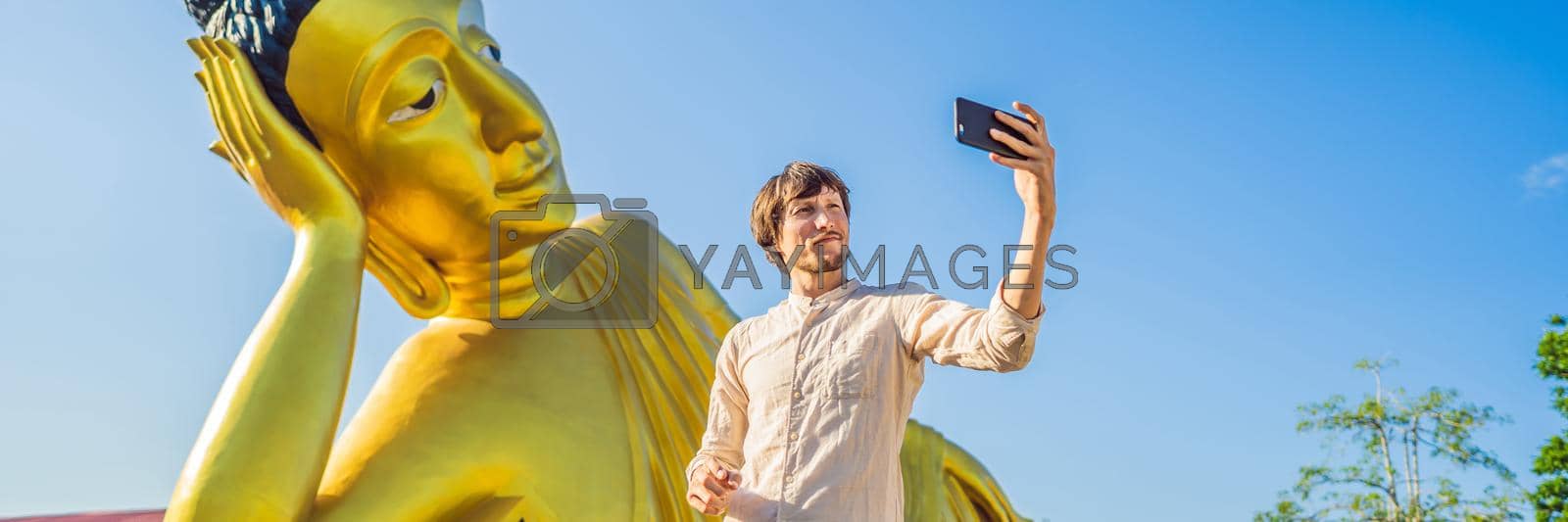 Royalty free image of Happy man tourist on background ofLying Buddha statue BANNER, LONG FORMAT by galitskaya