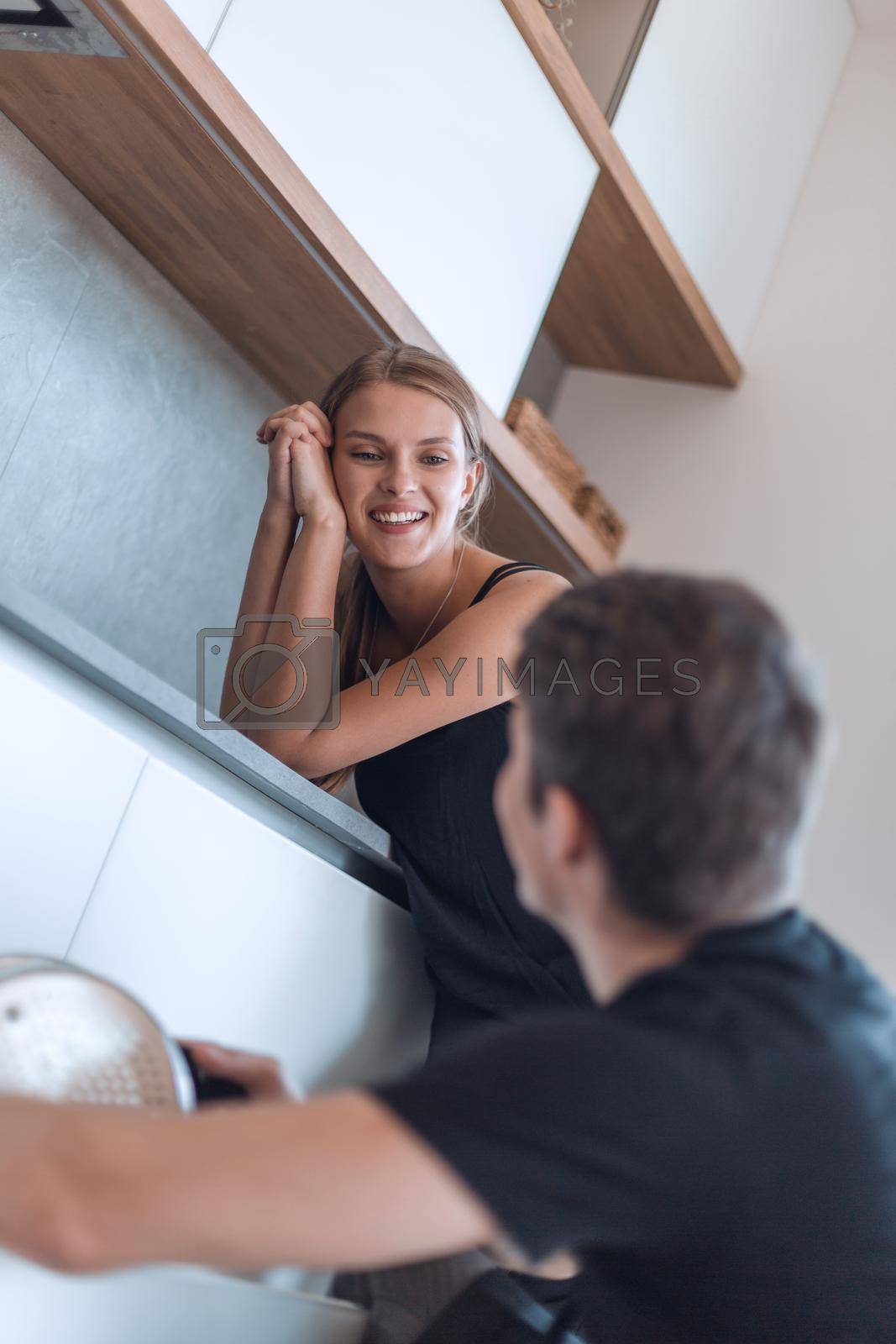 Royalty free image of happy husband gets the dishes out of the dishwasher by asdf
