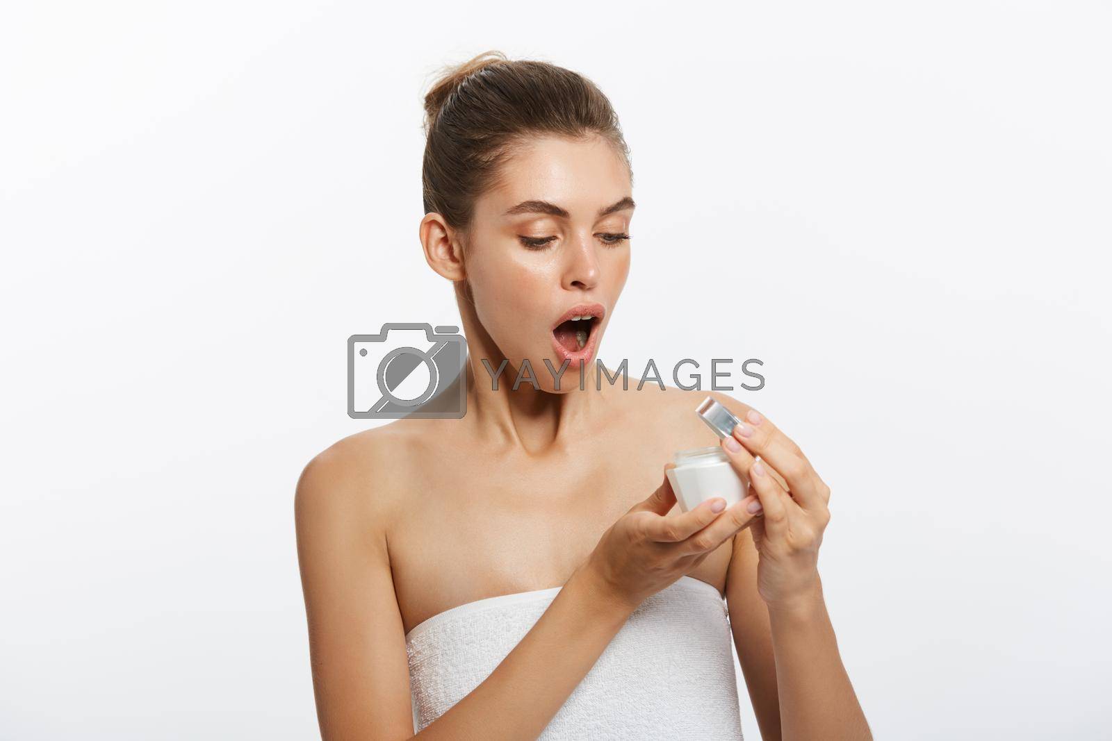Royalty free image of Beautiful young girl with moisturizer making surprise gesture. by Benzoix