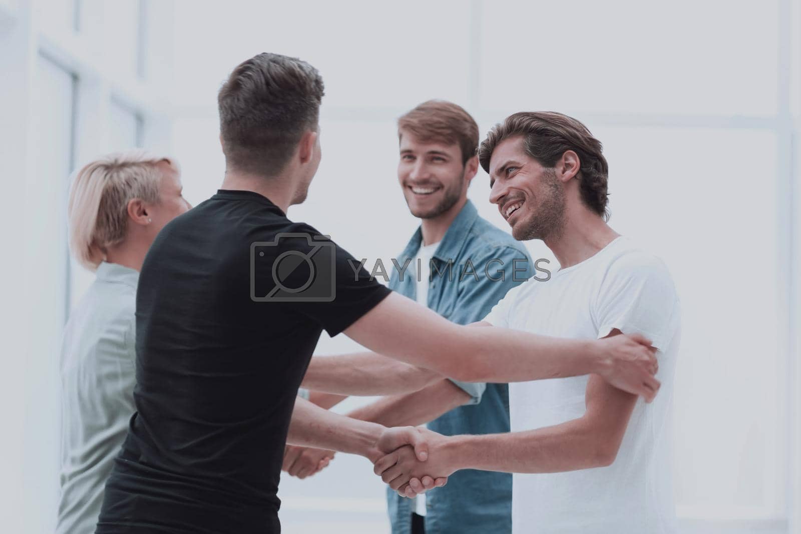 Royalty free image of colleagues shaking hands in the office lobby by asdf