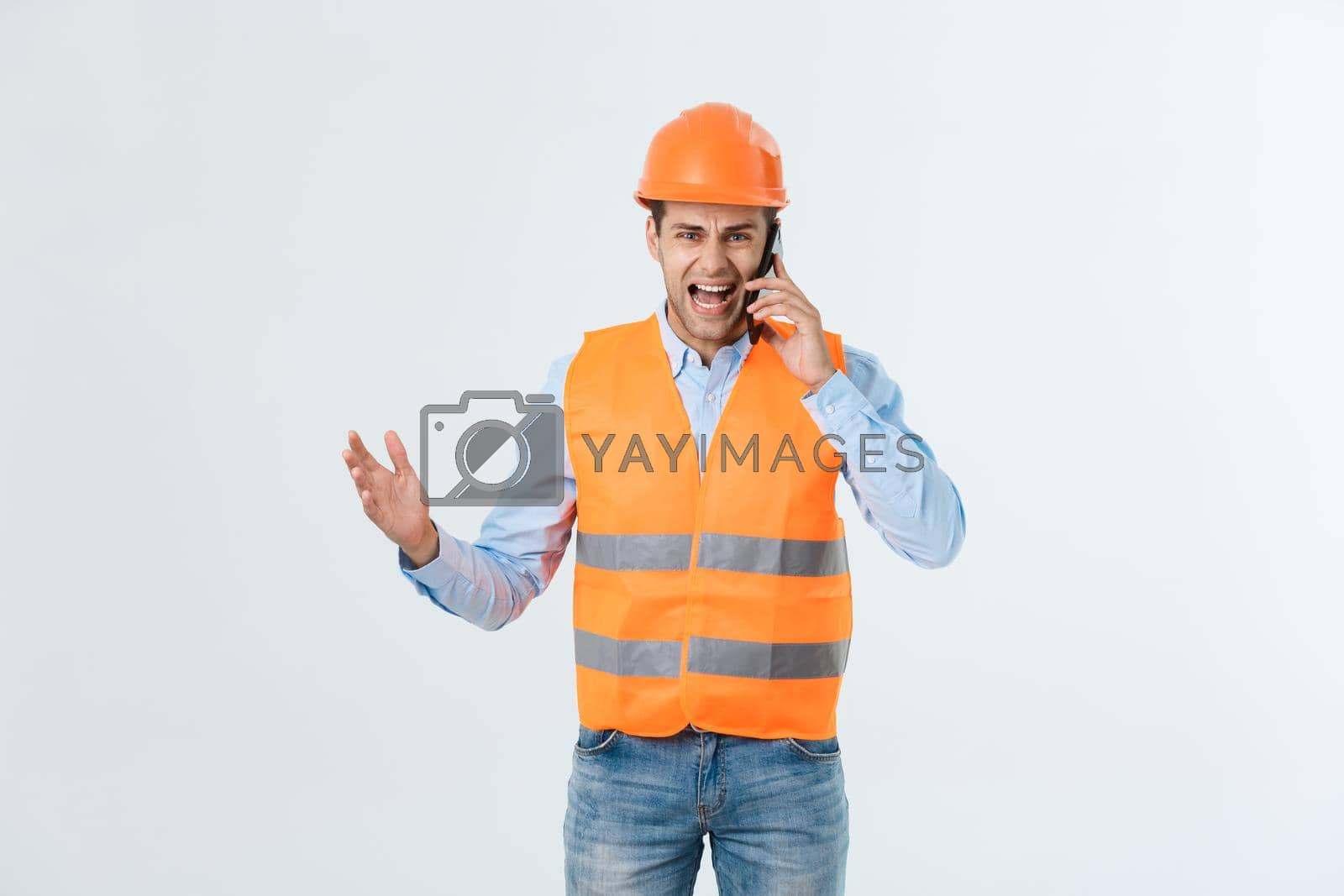 Construction engineer talking on mobile phone, serious adult male person using smartphone for communication with workers on building site