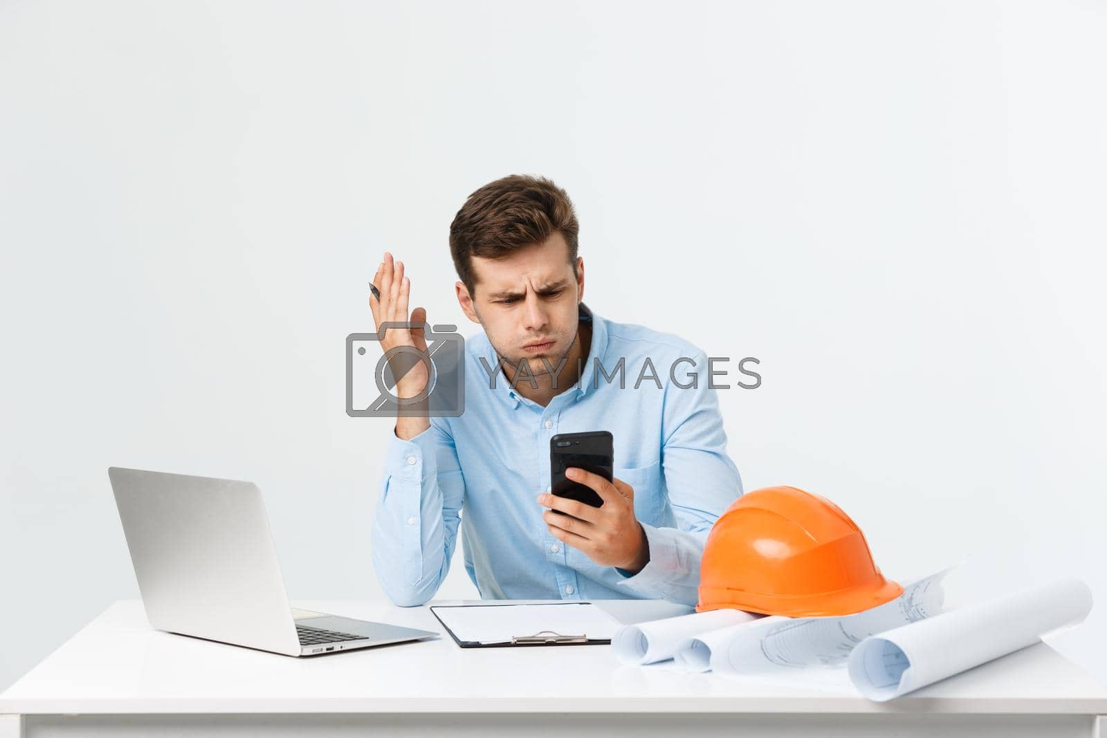 Royalty free image of Handsome young man serious working in engineering office. by Benzoix