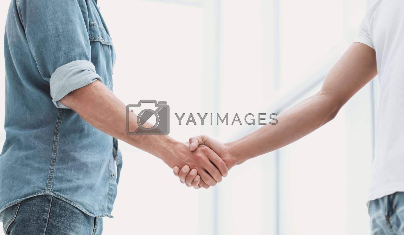 Royalty free image of business men shaking hands in the office lobby by asdf
