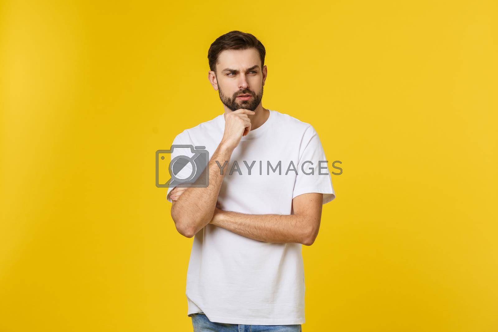 Royalty free image of Pensive curious man looking up in thinking pose trying to make choice or decision isolated on yellow background. by Benzoix