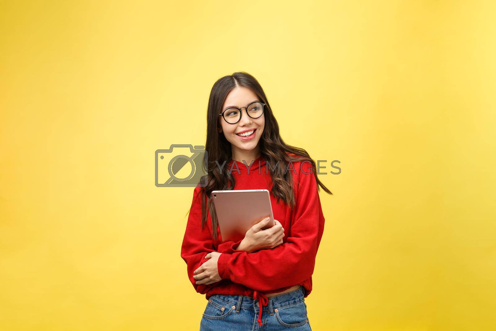 Royalty free image of Picture of happy teenage girl with tablet pc computer isolate on yellow background by Benzoix