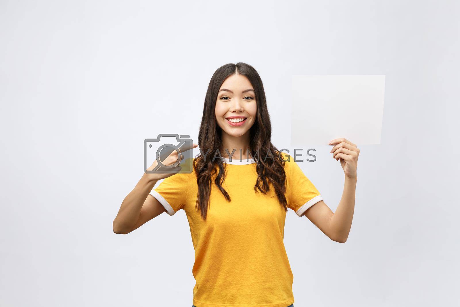 Royalty free image of surprised young girl in yellow shirt with white placard in hands isolated by Benzoix