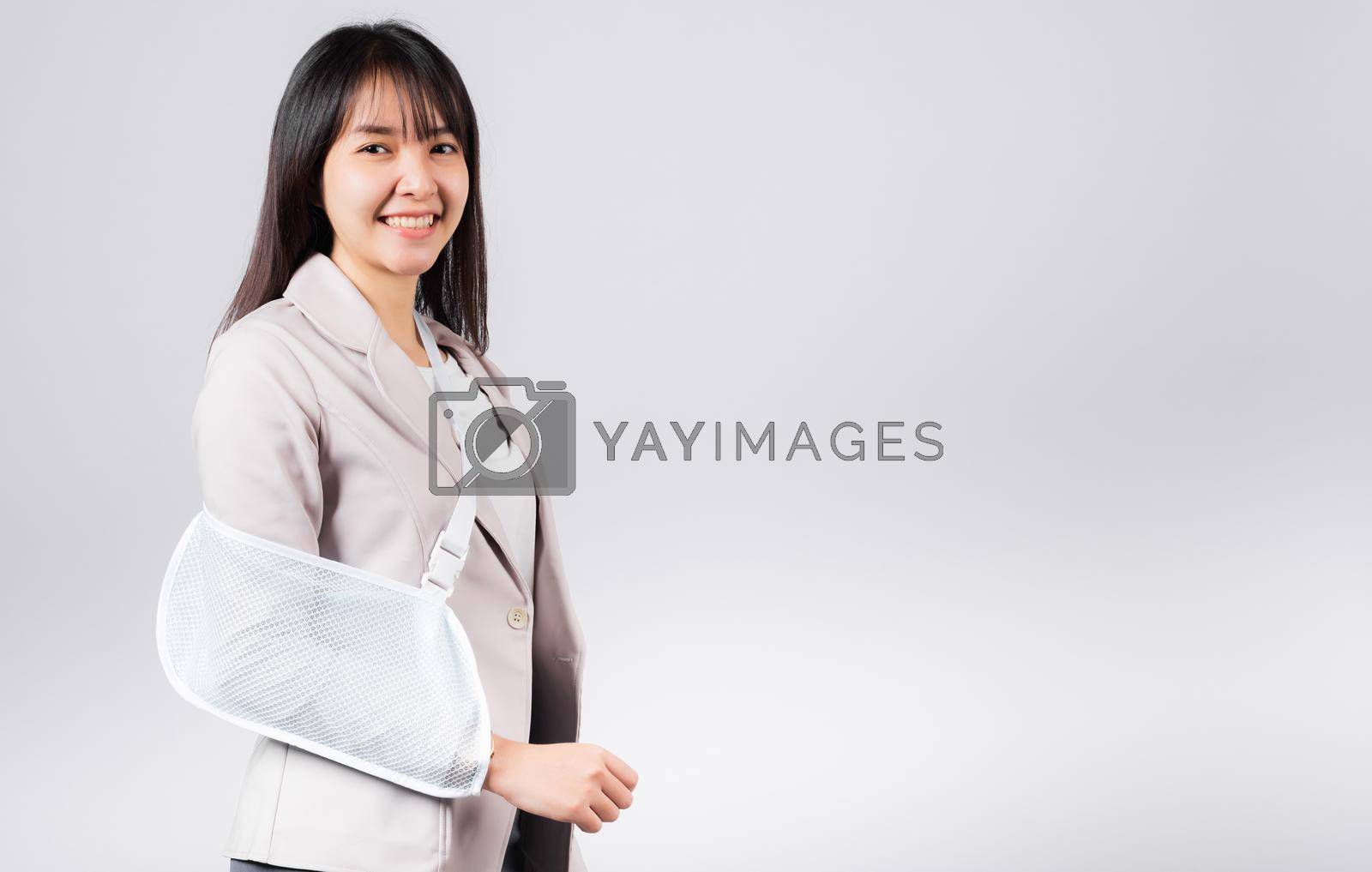 Royalty free image of Business woman confident smiling broken arm after accident and wear arm splint for treatment by Sorapop