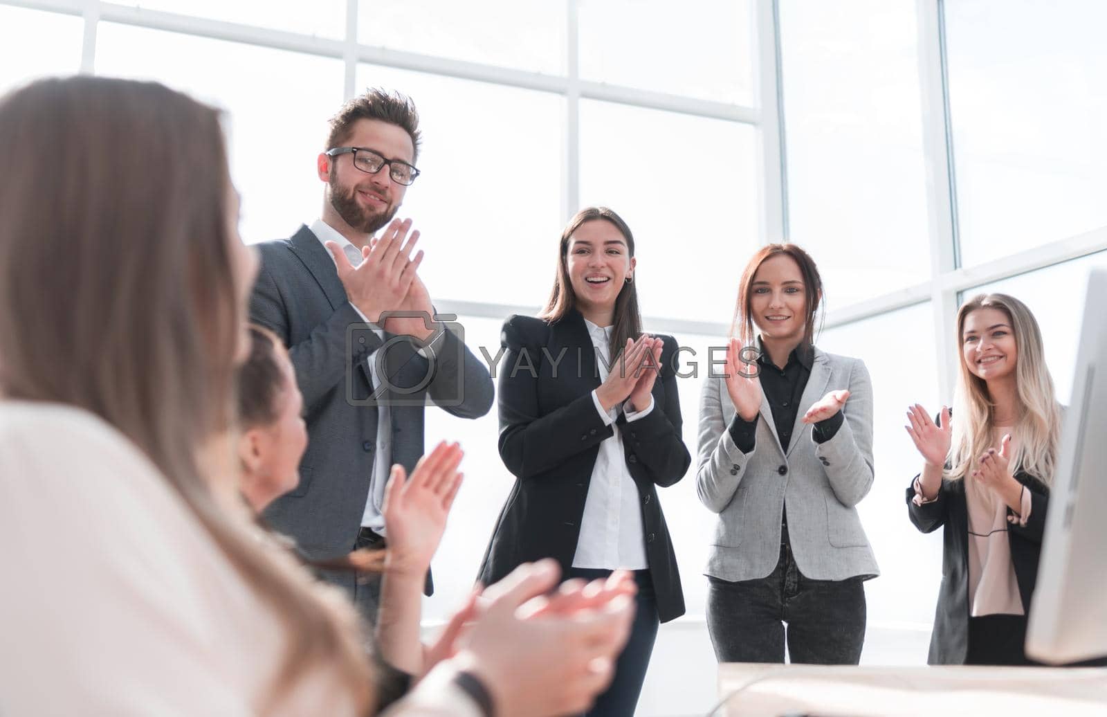Royalty free image of group of young employees applauding their success. by asdf