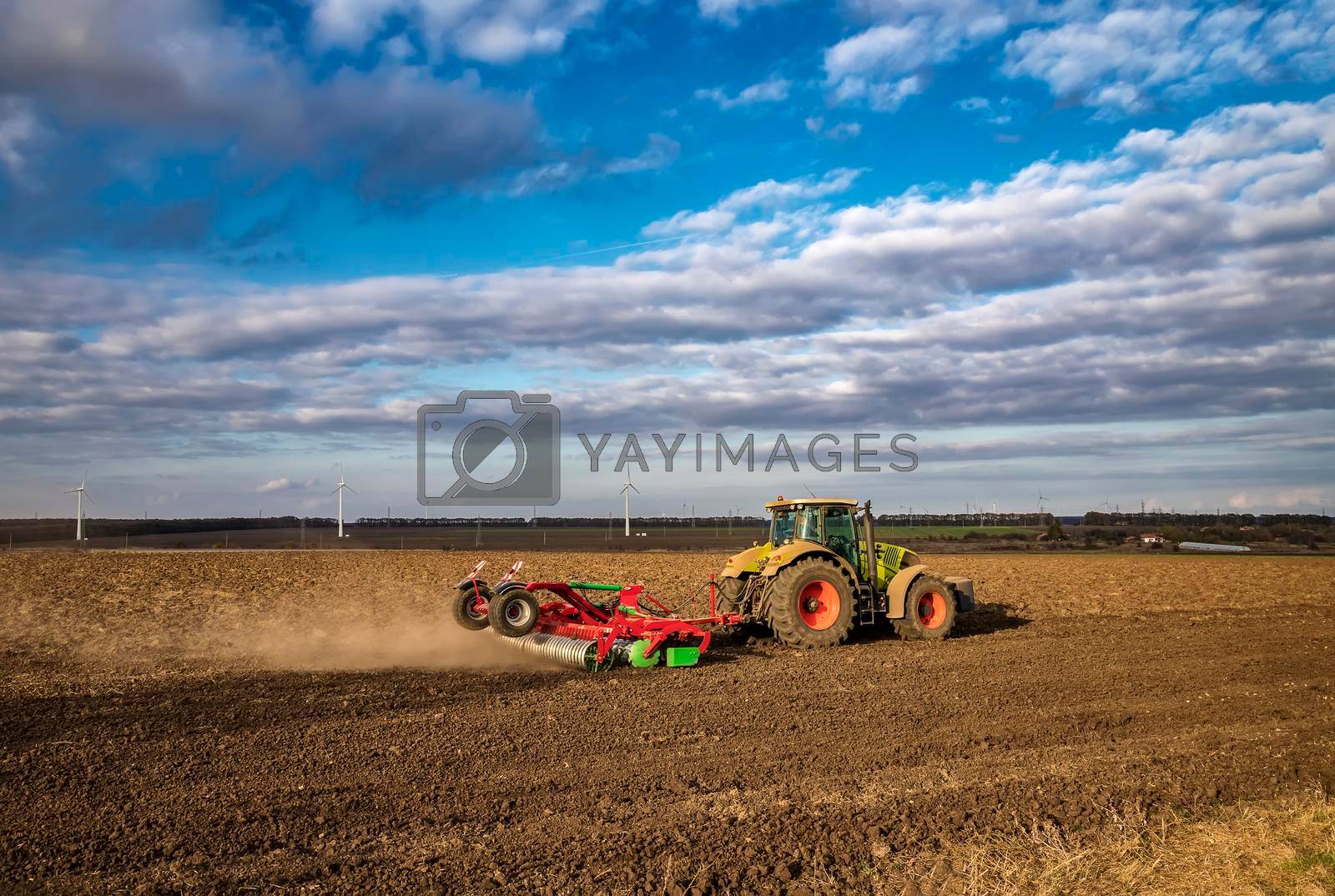 Royalty free image of The tractor prepares the ground for sowing and cultivation. Agriculture and agronomy concept. by EdVal