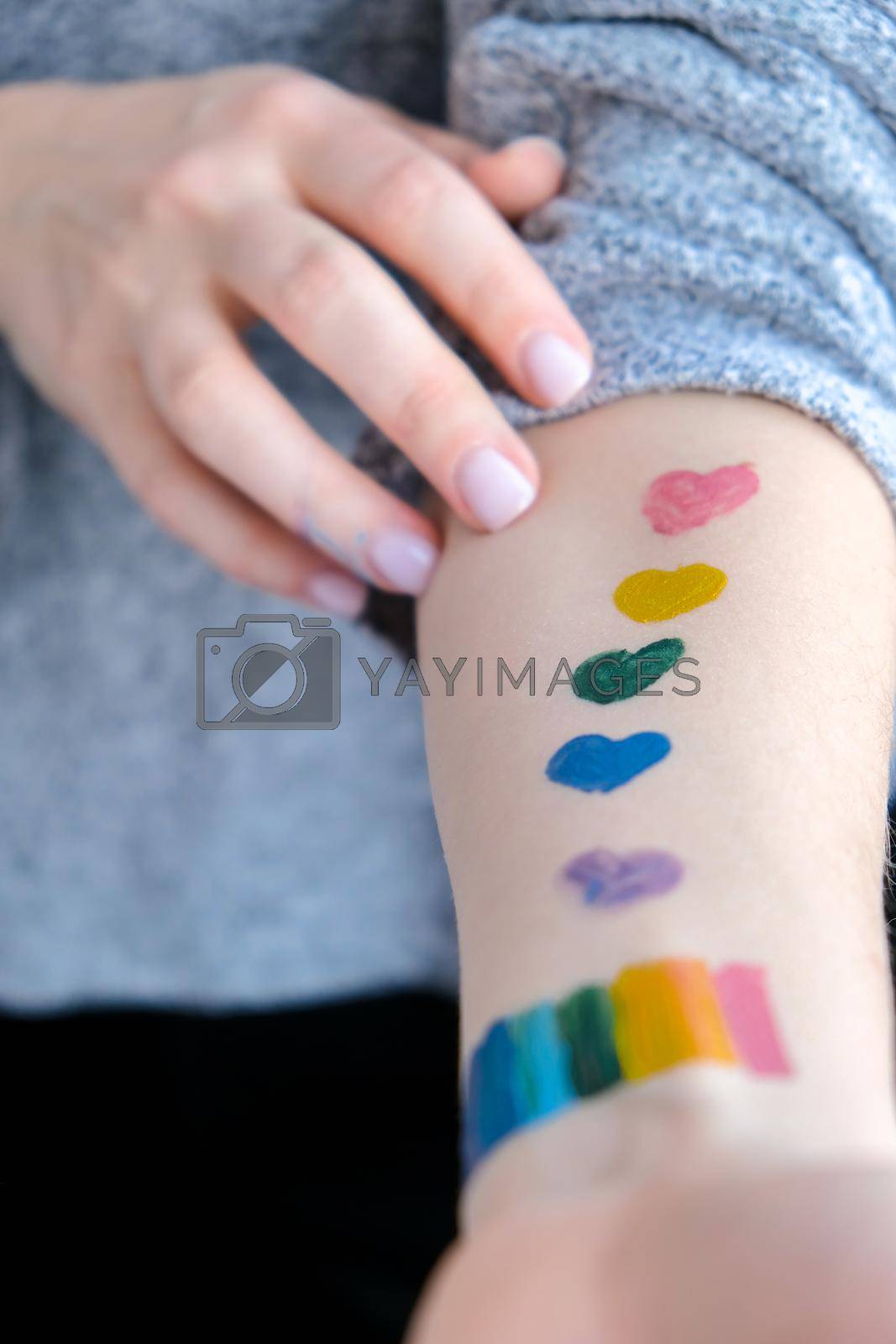 Royalty free image of Rainbow LGBTQ flag painted on hand. Support for lgbt community. Honour of pride month. Connecting people, touching hands. Selective focus by anna_stasiia