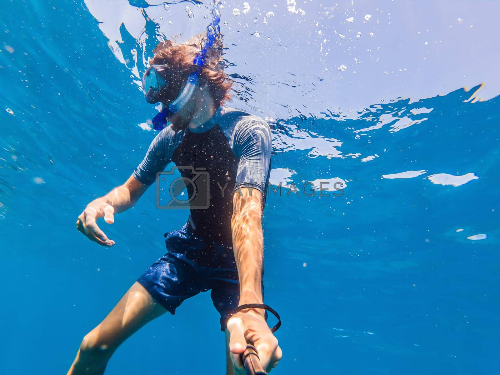 Royalty free image of Man with mask snorkeling in clear water by galitskaya