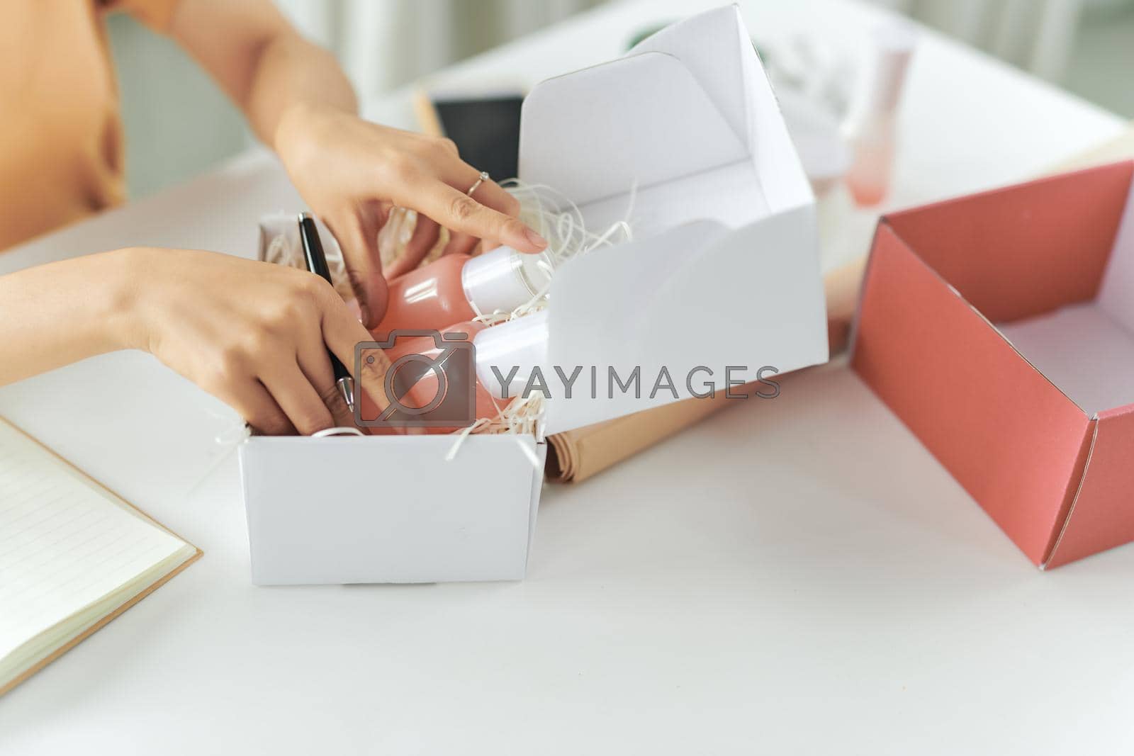 Royalty free image of Woman picking beauty box, package and collect the cosmetics product by makidotvn