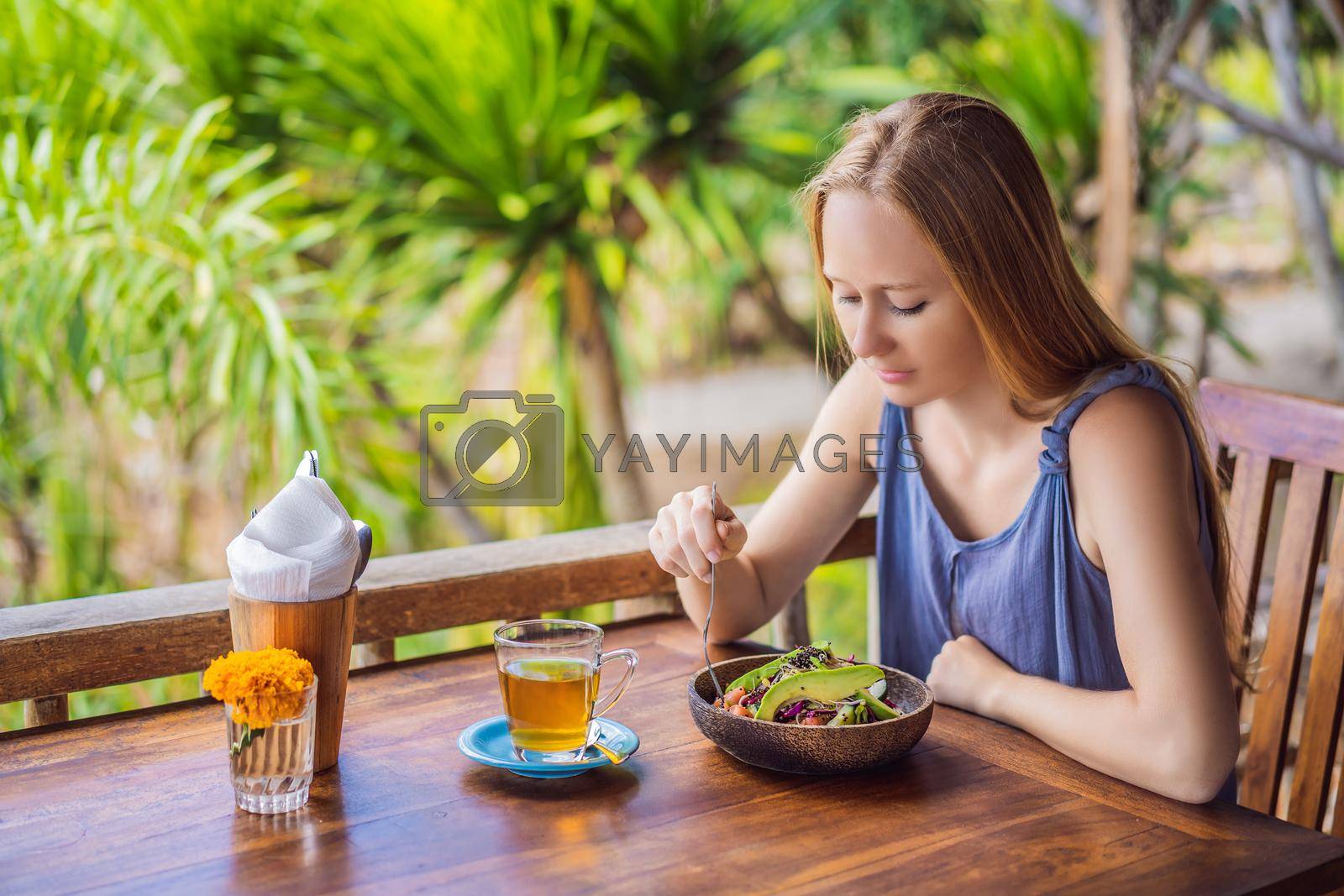 Royalty free image of Woman eating quinoa salad. Eat healthy food lifestyle concept with beautiful young woman by galitskaya