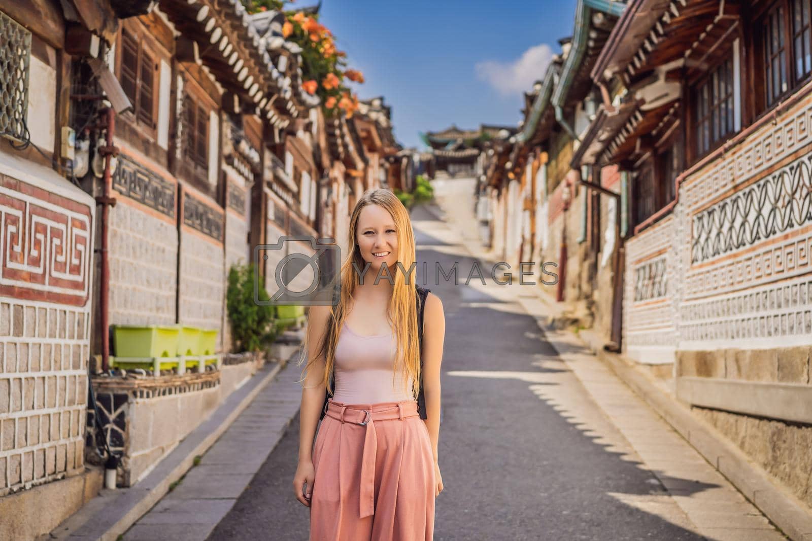 Royalty free image of Young woman tourist in Bukchon Hanok Village is one of the famous place for Korean traditional houses have been preserved. Travel to Korea Concept by galitskaya