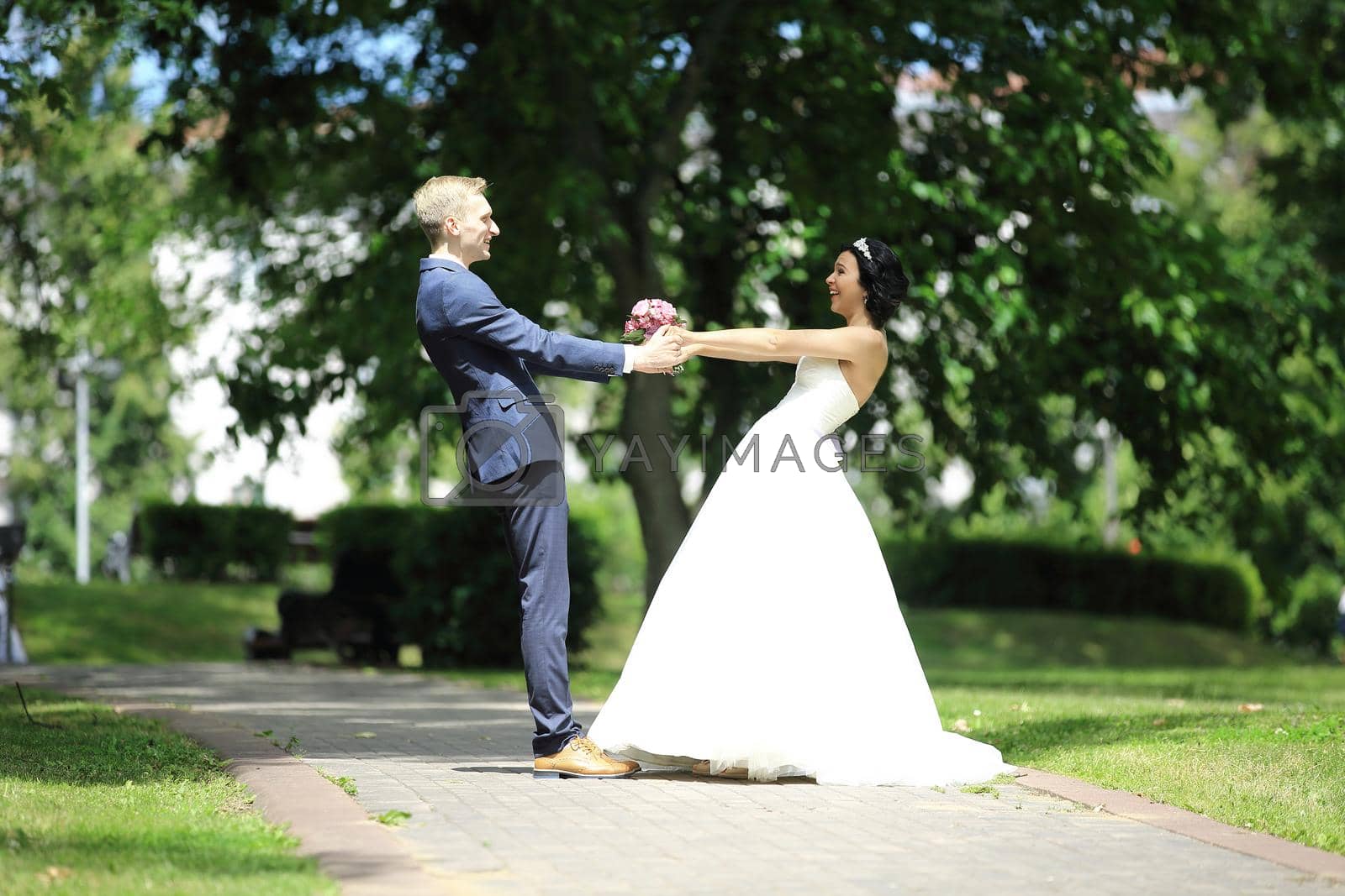 Royalty free image of bride and groom circling in the Park. by SmartPhotoLab