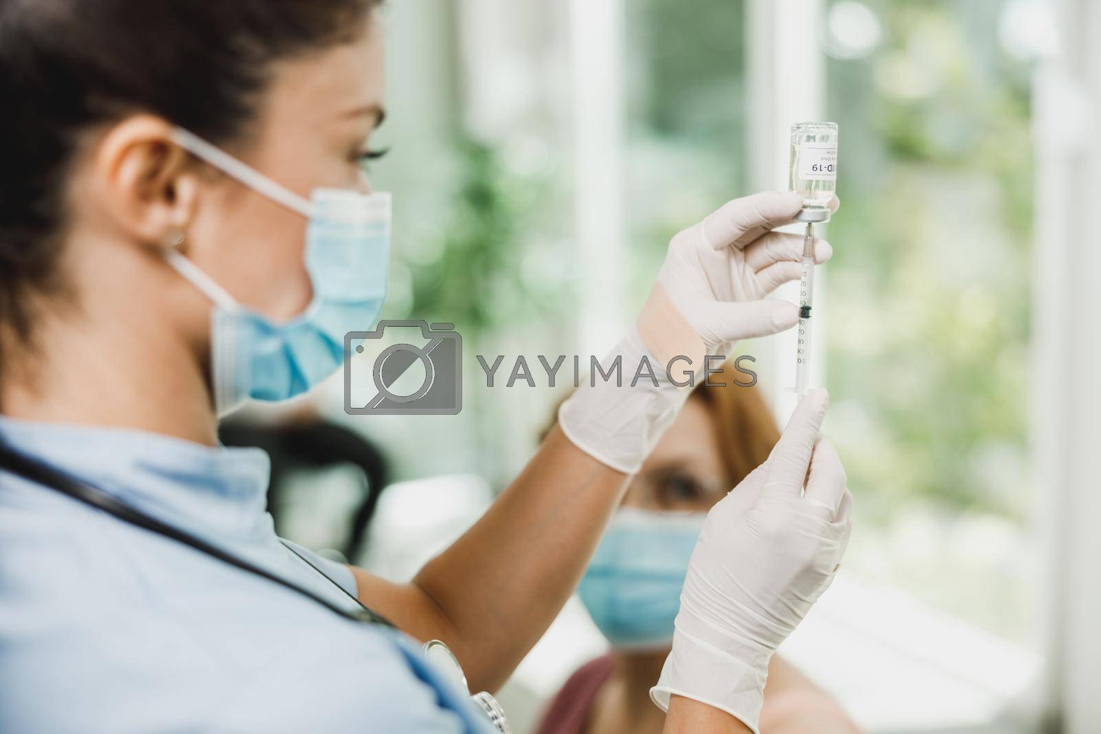 Royalty free image of Nurse Holding Coronavirus Vaccine and Syringe by MilanMarkovic78