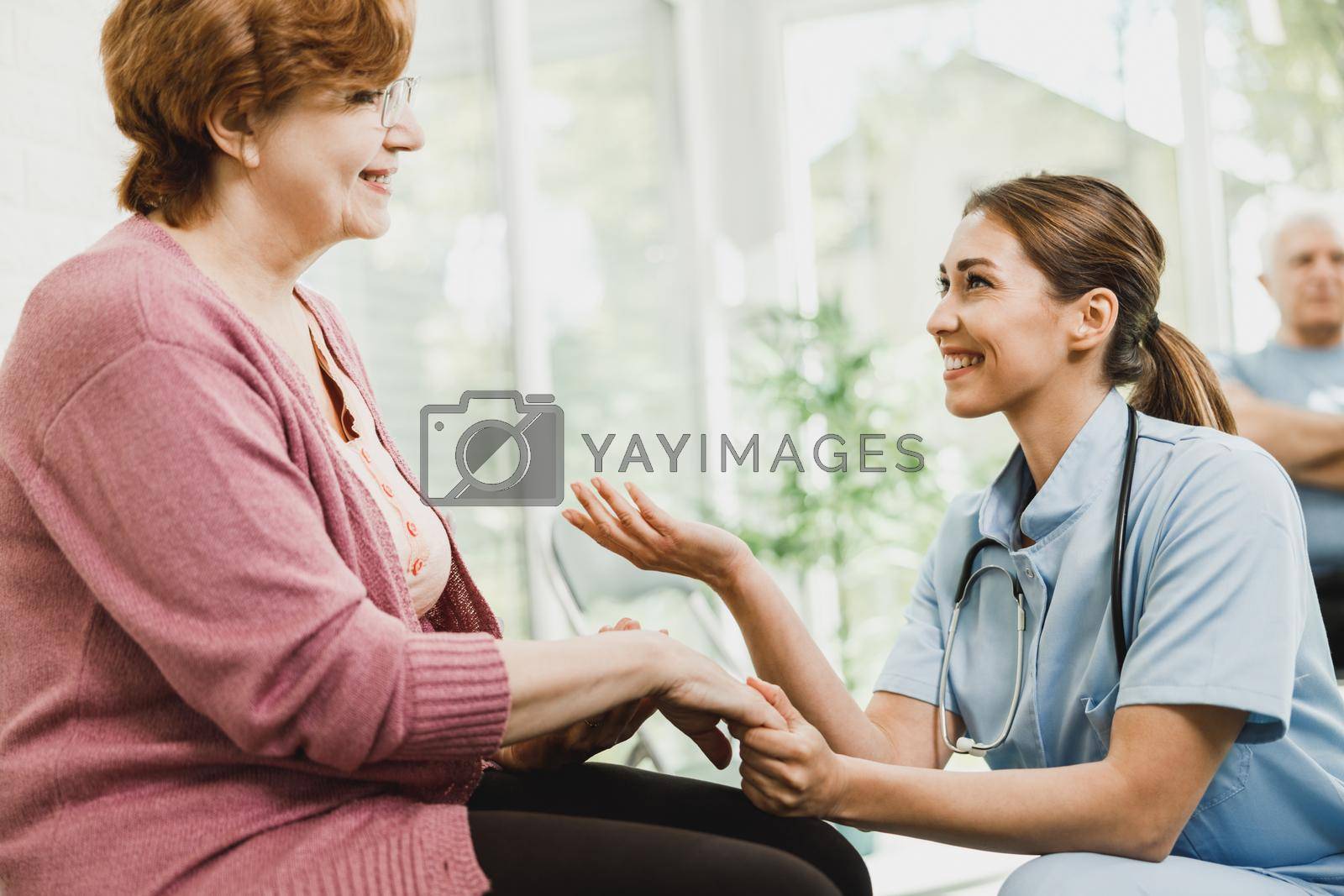 Royalty free image of Senior Woman Talking To Caring Nurse At Waiting Room by MilanMarkovic78