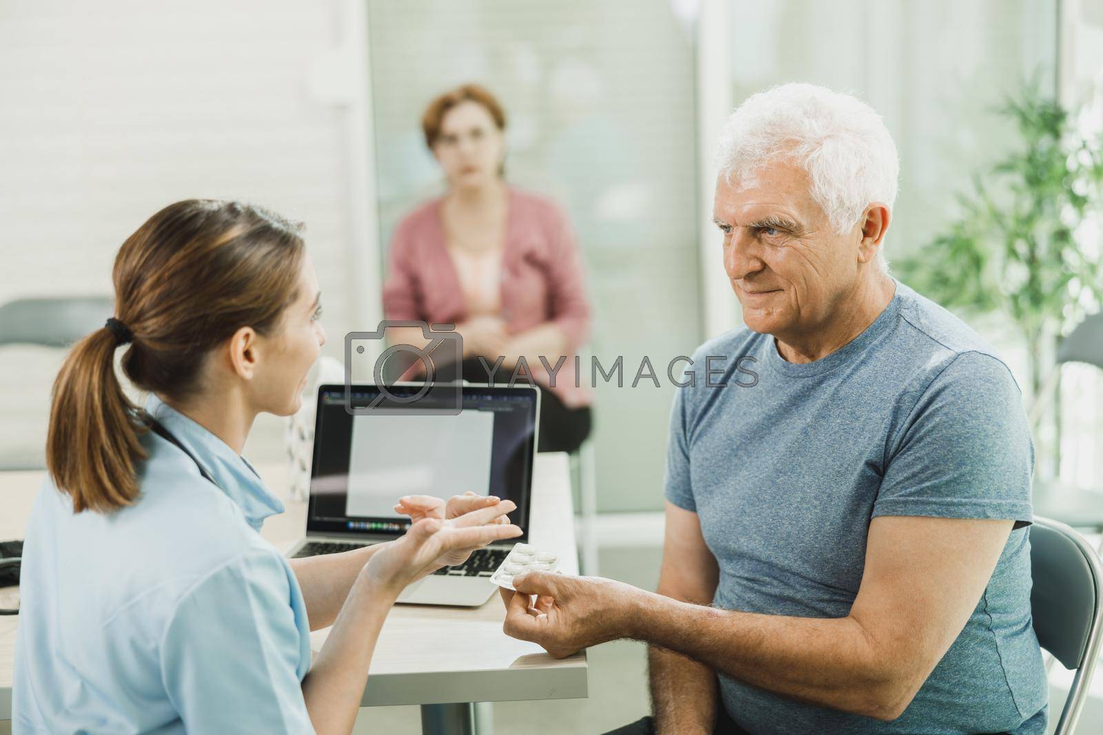 Royalty free image of Caring Nurse Talking To Senior Man At Hospital Waiting Room by MilanMarkovic78
