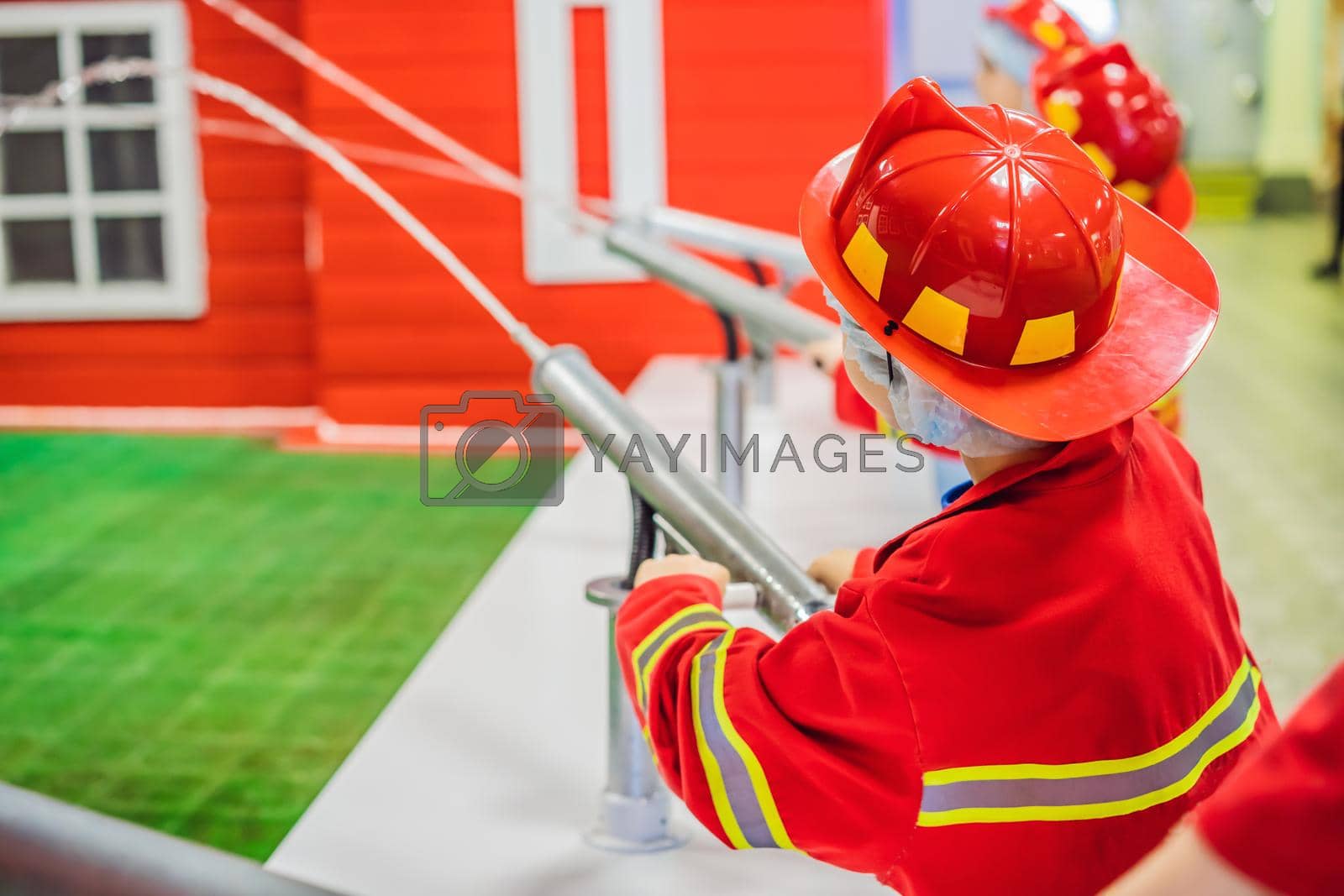 Royalty free image of Expressive cute toddler with fireman's outfit playing fireman by galitskaya