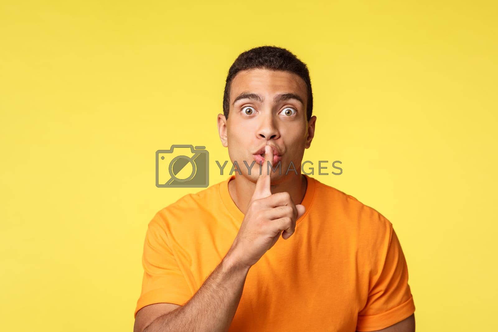 Royalty free image of Hush dont say anyone. Handsome man have secret asking swear not tell anyone, prepare surprise new year party for girlfriend, telling office coworker who is secret santa, press finger lips and shush by Benzoix