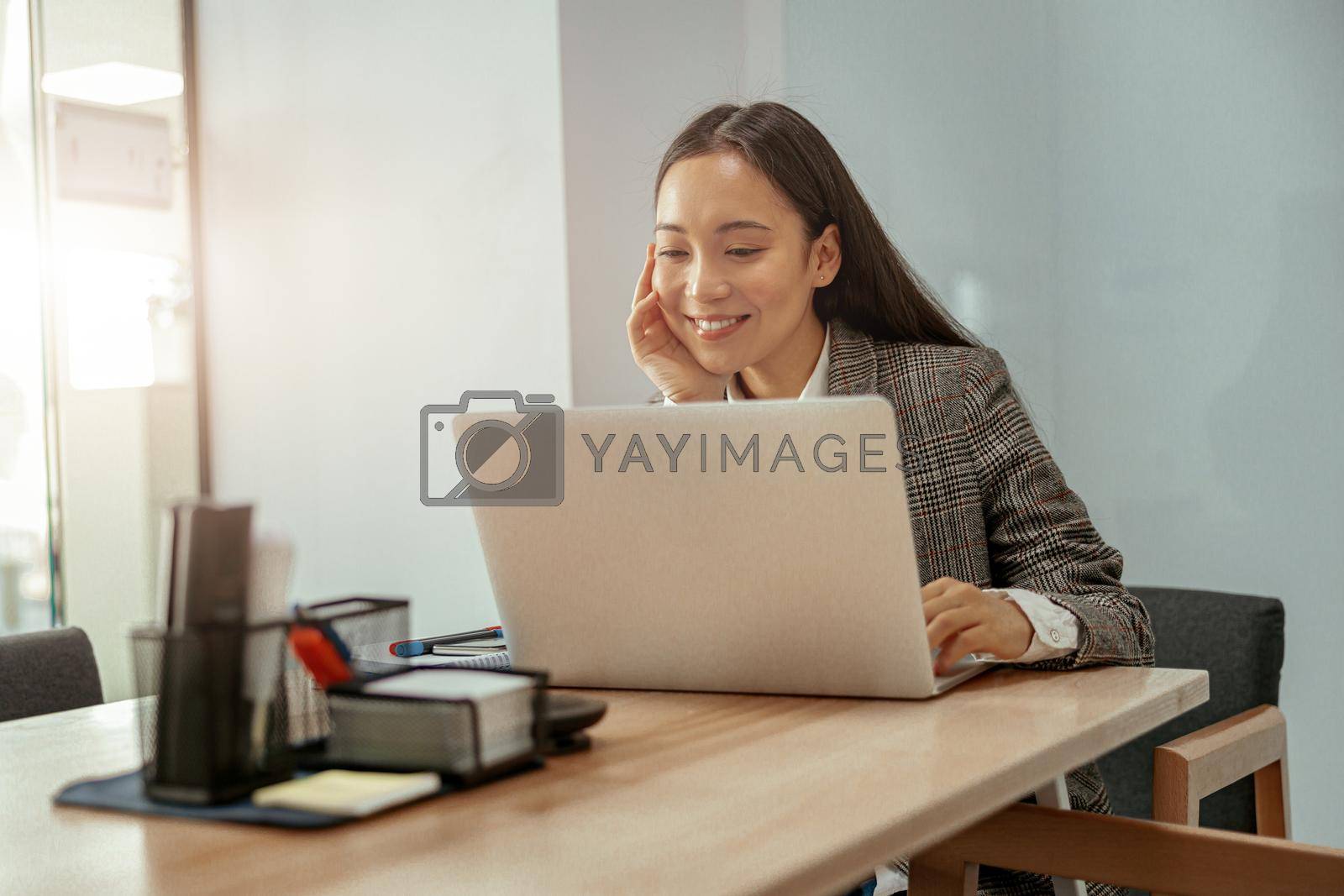 Royalty free image of Smiling beautiful business asian woman working in office use computer by Yaroslav_astakhov