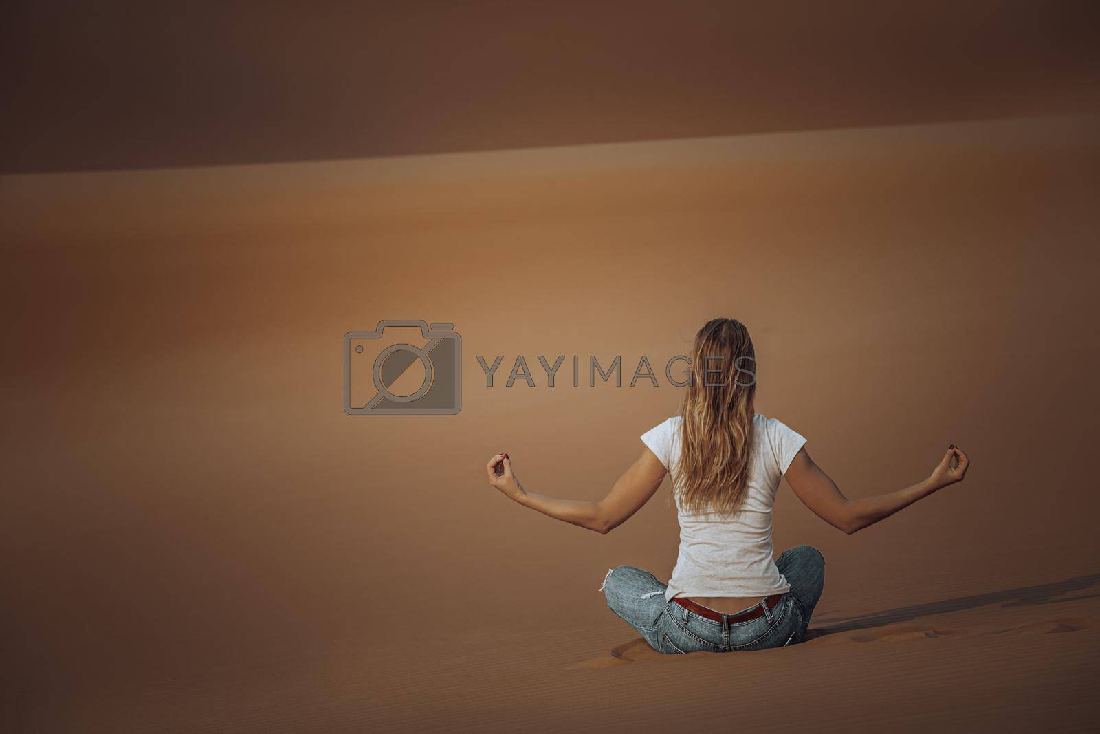 Back Side of Young Female Doing Yoga Exercises in the Desert. Meditation on Beautiful Peaceful Sandy Background. Soul Balance and Harmony Concept.