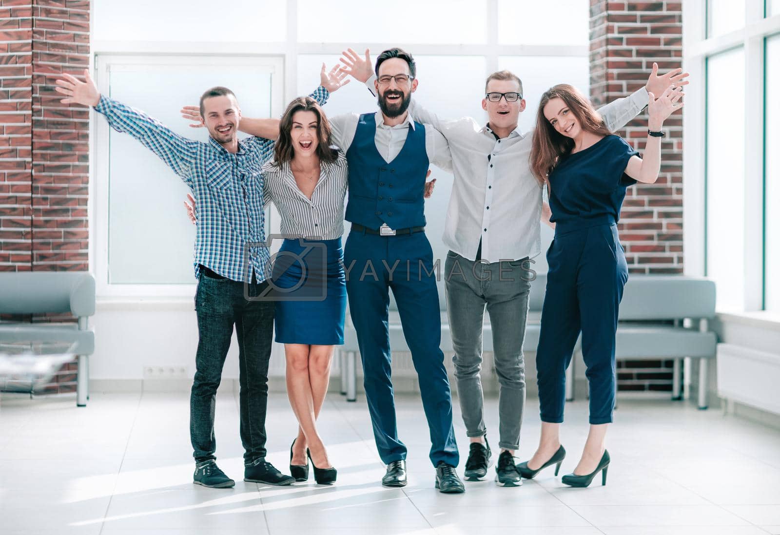 Royalty free image of happy business team standing in a bright office by SmartPhotoLab
