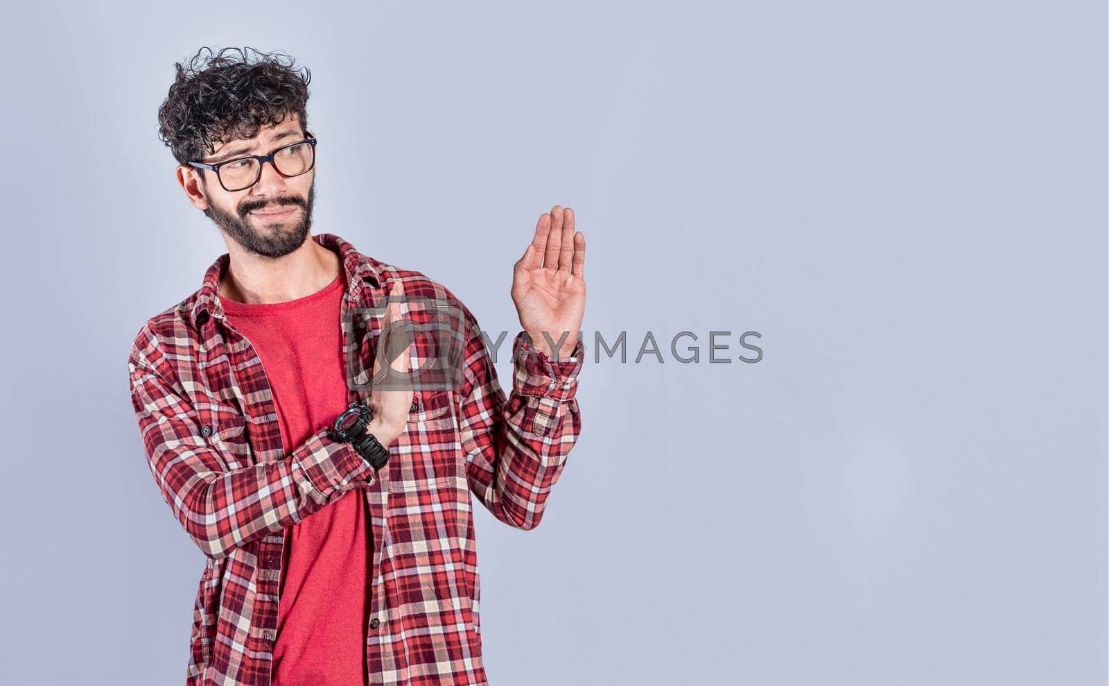 Royalty free image of Disgusted intense man with rejection gesture, pulls palms in rejection, frowns in disgust by isaiphoto