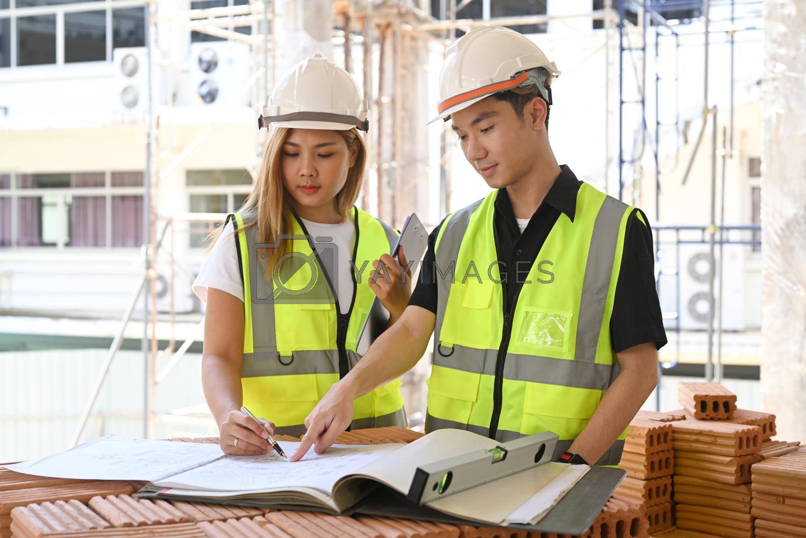 Royalty free image of Civil engineer and specialists working, checking plan together at construction site. Industry, Engineer, construction concept by prathanchorruangsak
