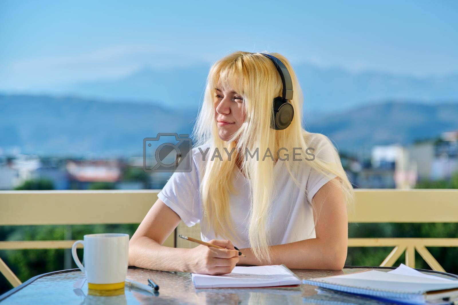 Royalty free image of Portrait of a teenage student studying at home, outdoor terrace by VH-studio