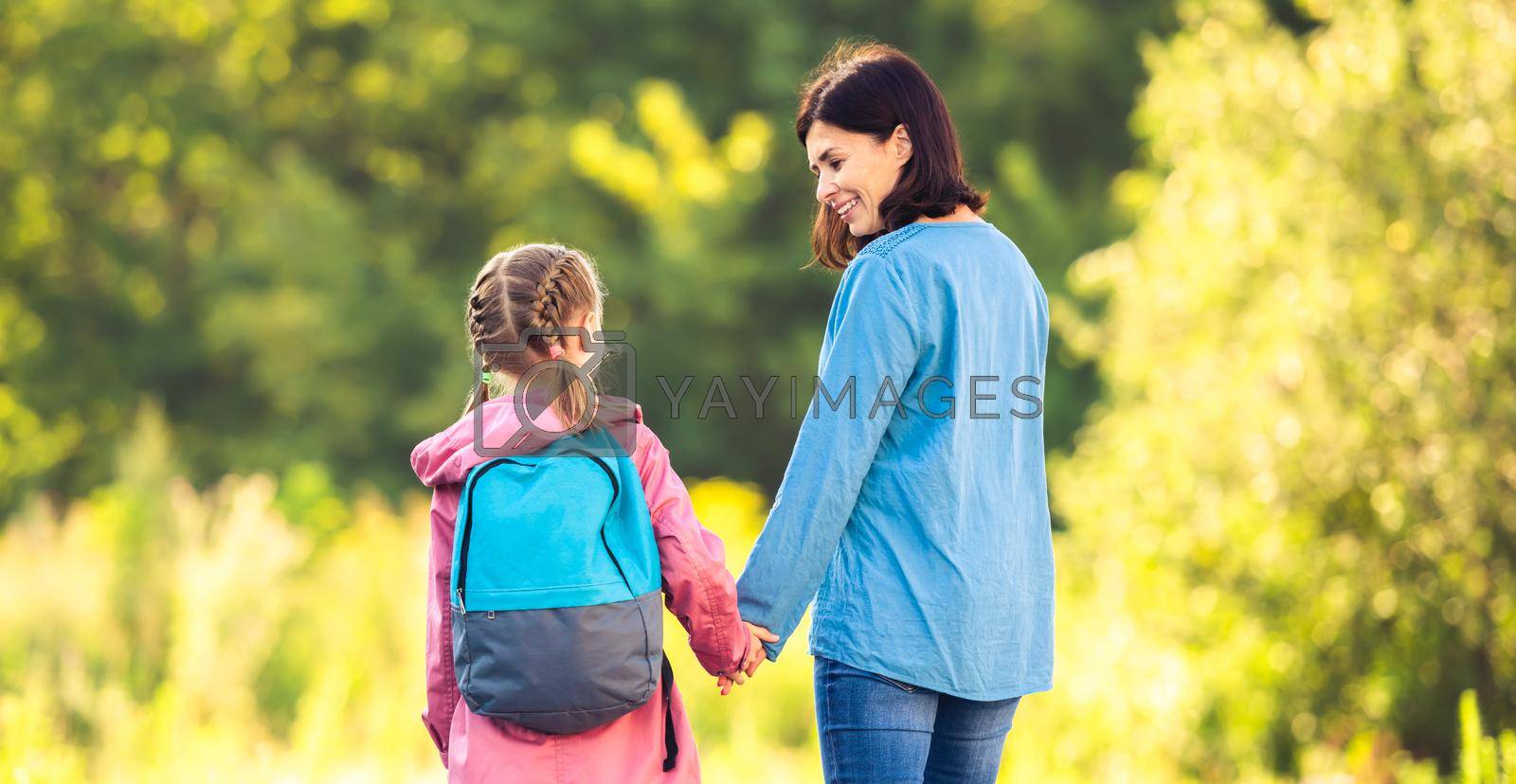 Royalty free image of Mother meeting primary schoolgirl after classes by GekaSkr