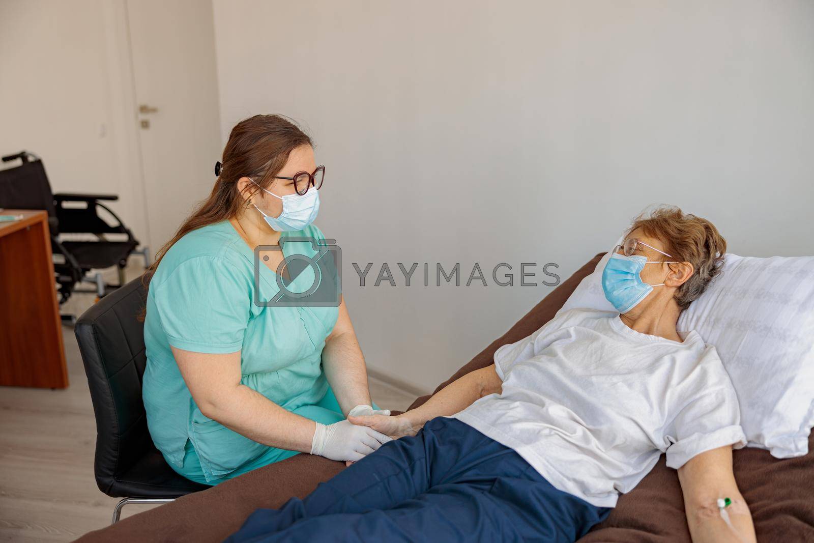Royalty free image of Professional Nurse controls drip of her patient in modern medicine clinic by Yaroslav_astakhov