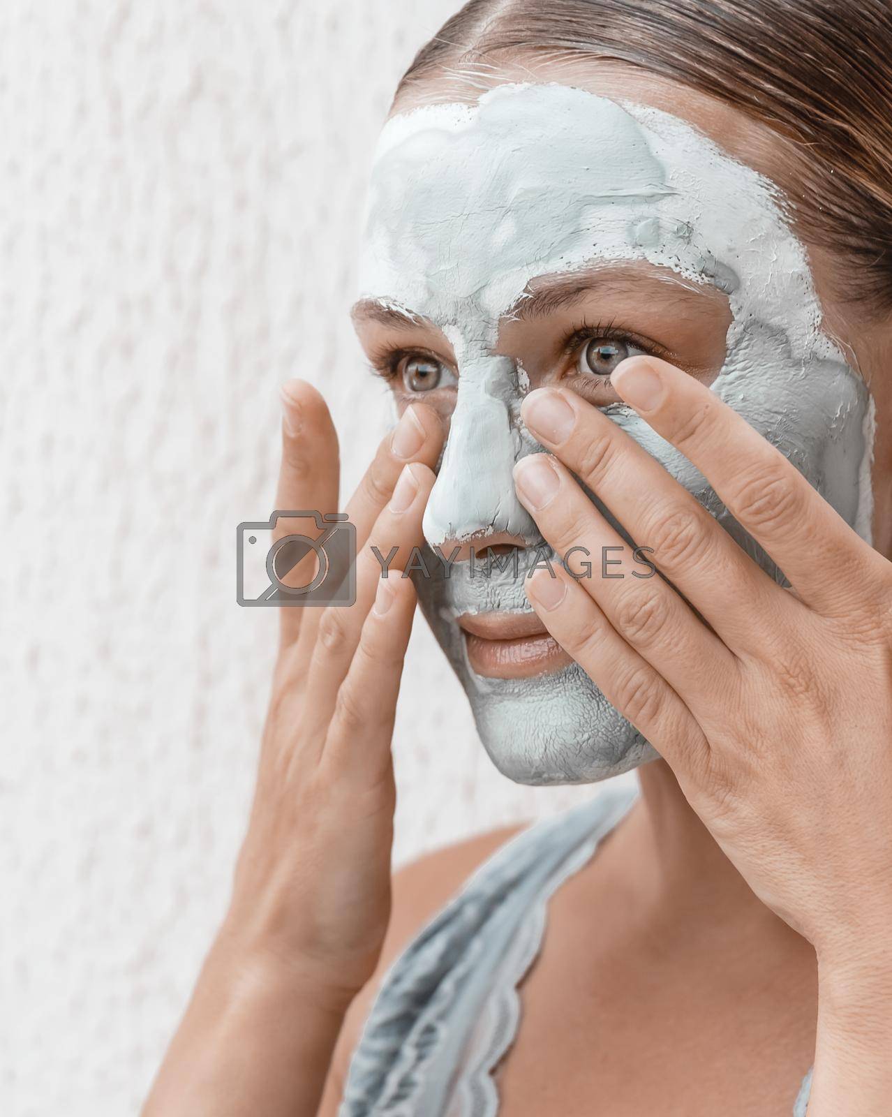 Portrait of a Nice Female Apply a Cream Mask in the Evening on the Eyes Before Sleep. Using Blue Clay for Perfect Skin. Health Care Concept.