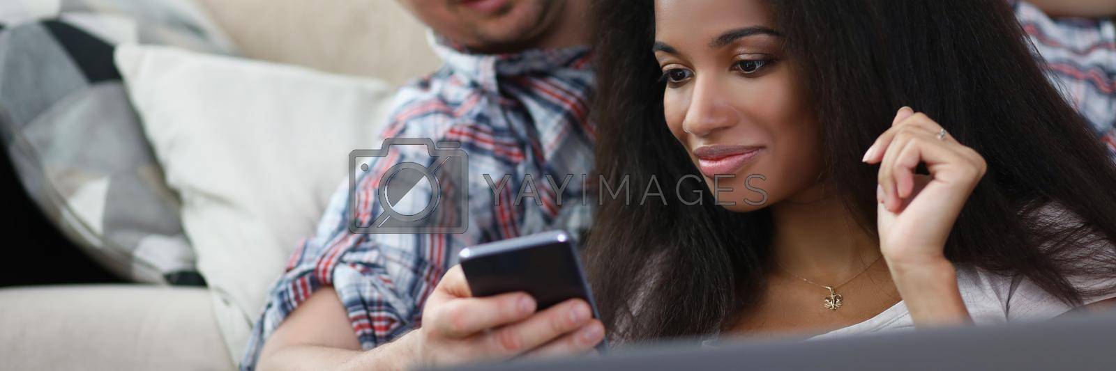 Royalty free image of Middle aged man show content on phone to latin female friend by kuprevich