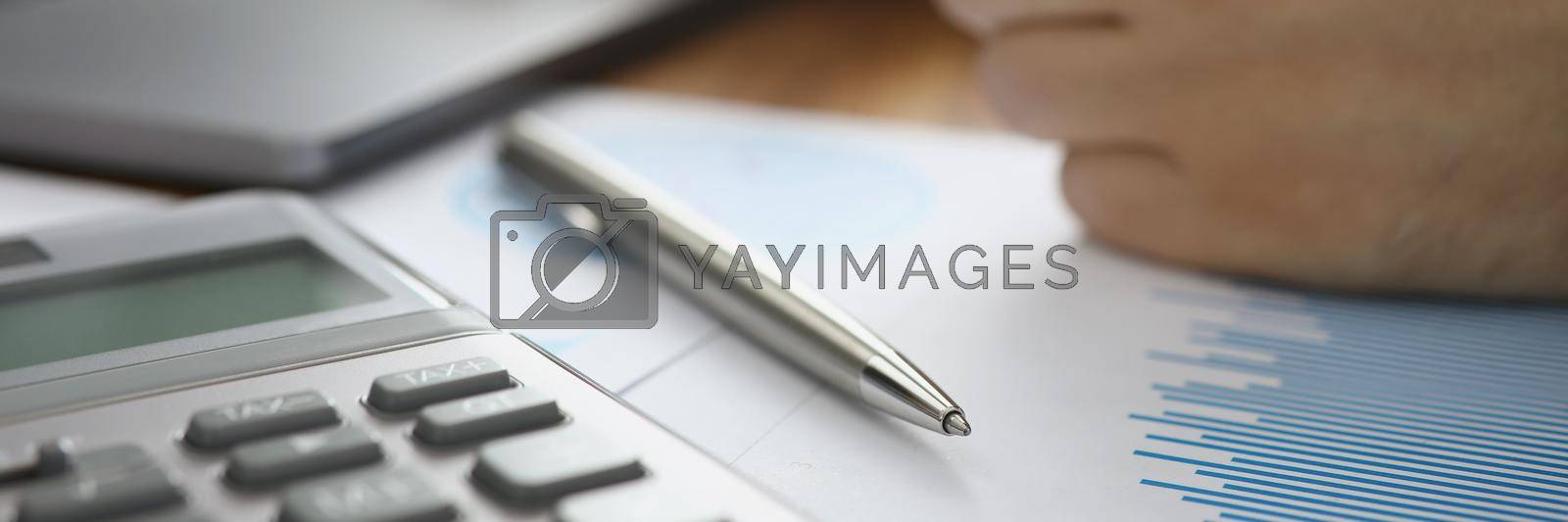 Royalty free image of Person typing on laptop and calculating numbers in office by kuprevich